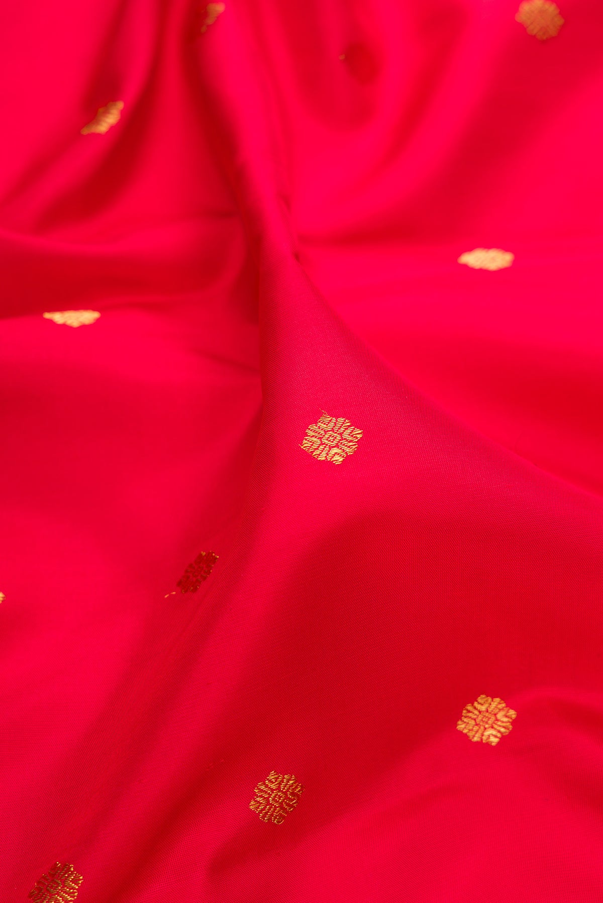 Close up of Pure Silk Pure Zari Red Kanjivaram Saree with Zari Butta on the body and Fancy Border.  displaying folds