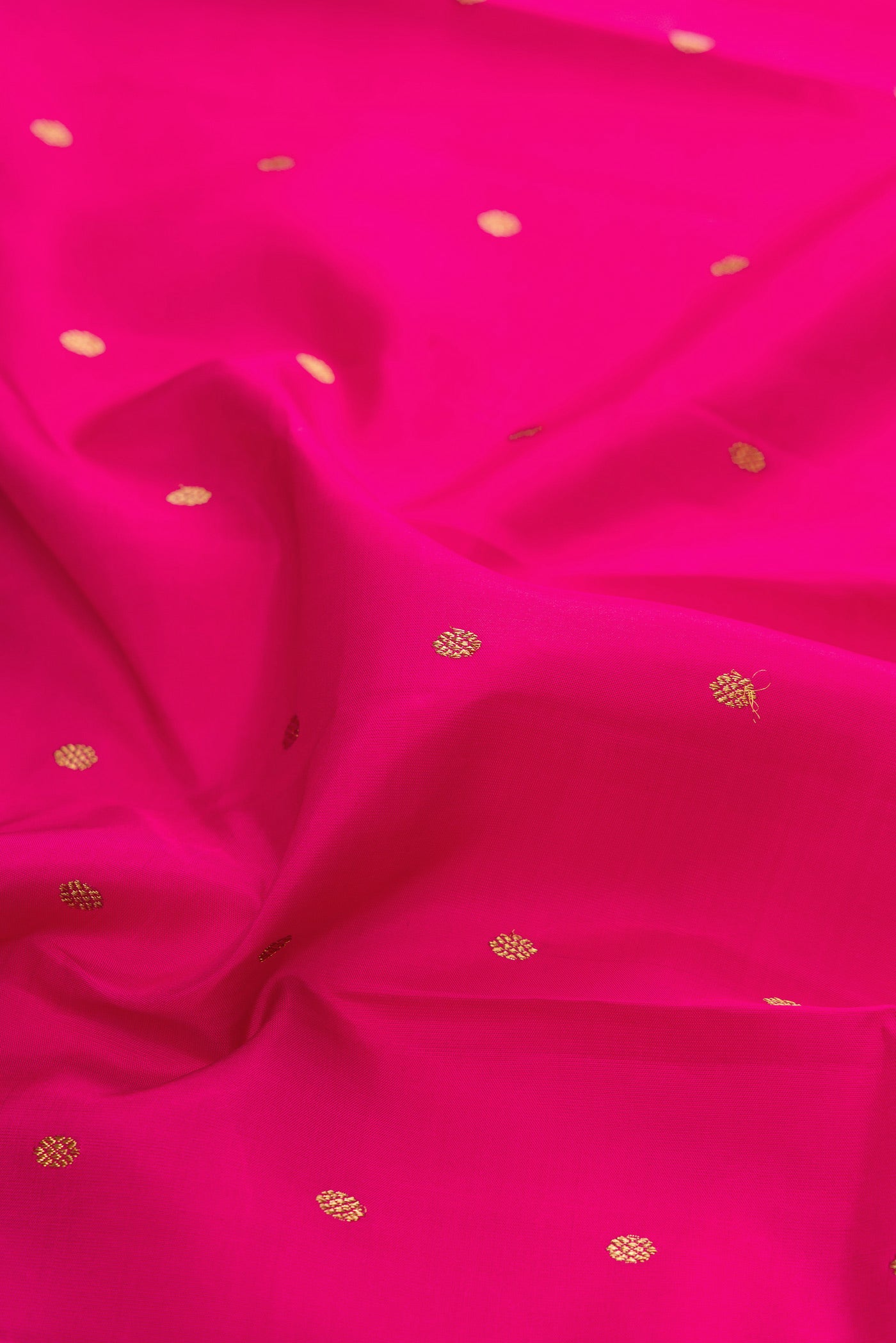 Close up of Pure Silk Pure Zari Dark Pink Kanjivaram Saree with Zari Butta on the body and Zari Border.  displaying folds