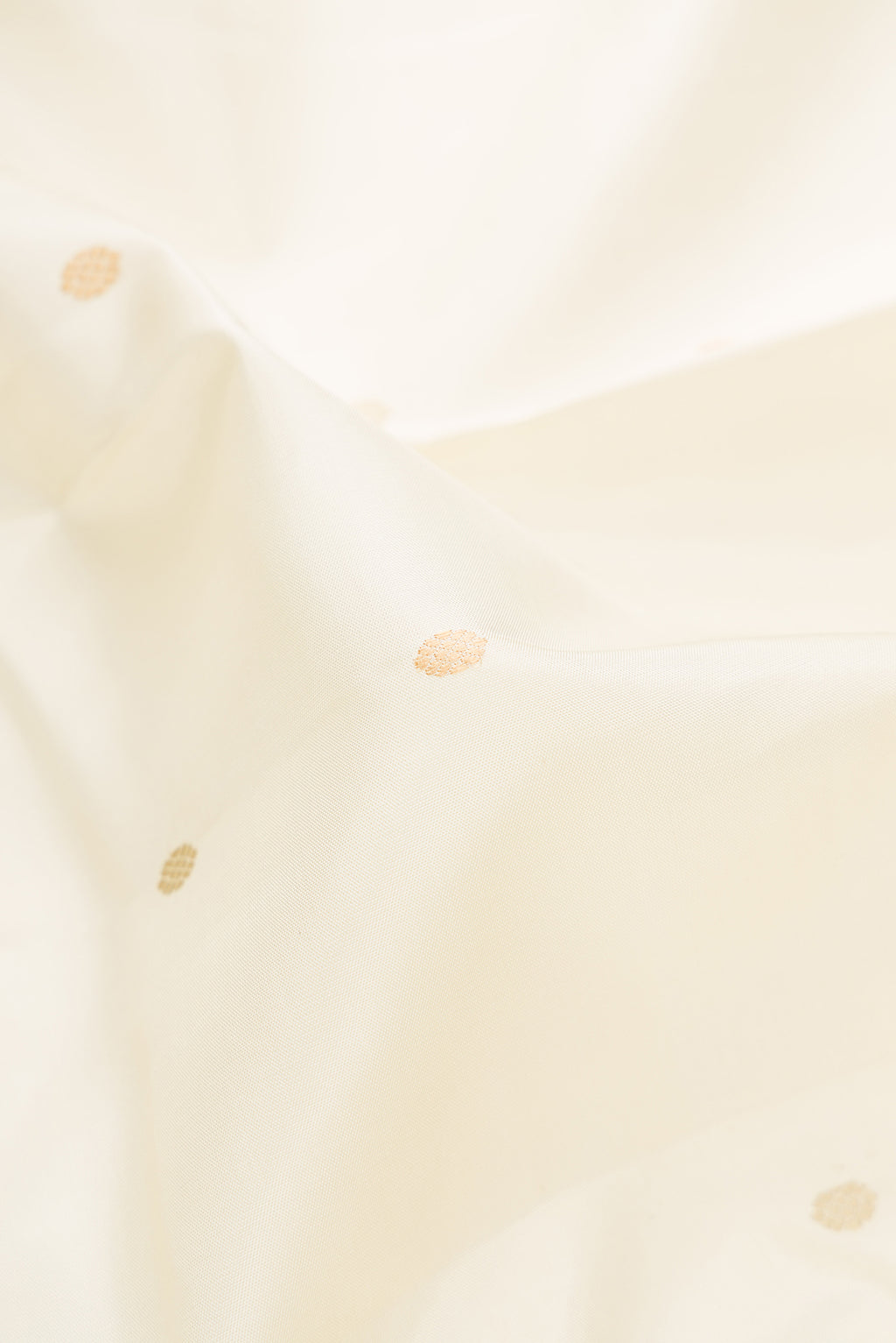 Close up of Off White Kanjivaram Silk Saree with Thread Butta on the body and Thread Border.  displaying folds