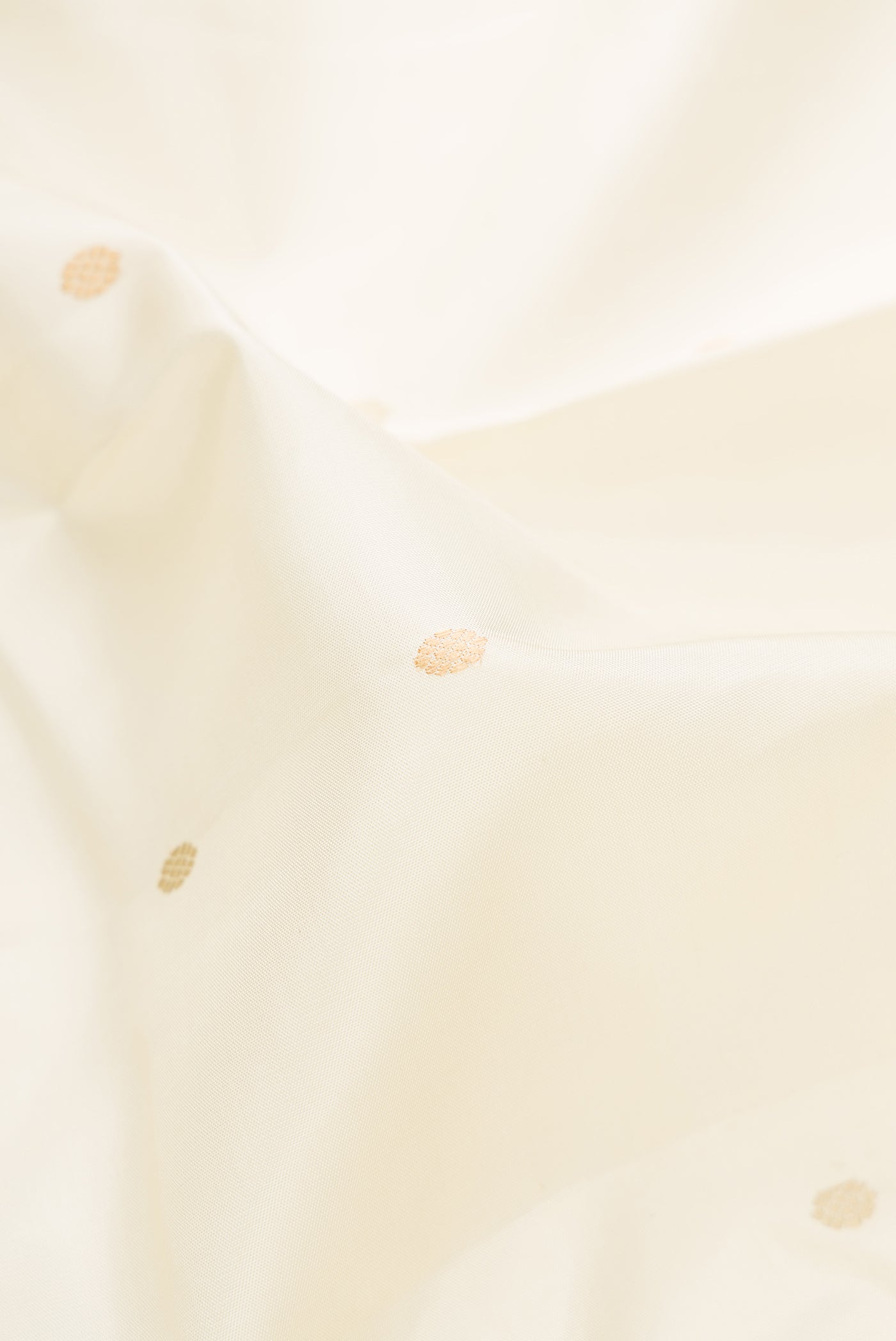 Close up of Off White Kanjivaram Silk Saree with Thread Butta on the body and Thread Border.  displaying folds