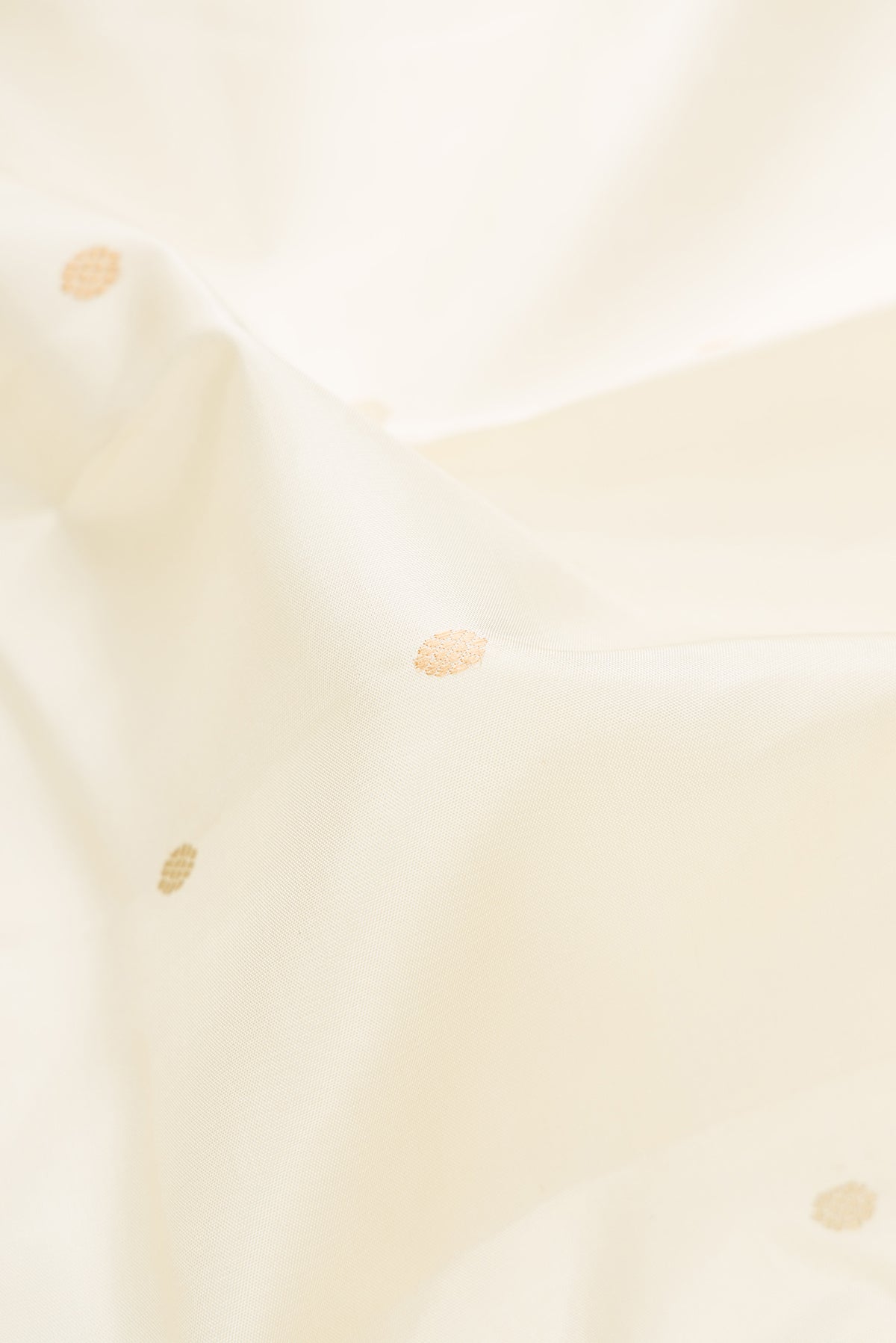 Close up of Off White Kanjivaram Silk Saree with Thread Butta on the body and Thread Border.  displaying folds