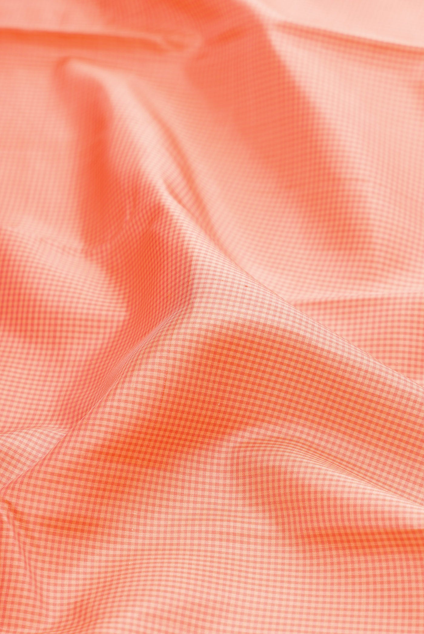 Close up of Peach Kanjivaram Silk Saree with Zari Butta on the body and Plain Border.  displaying folds