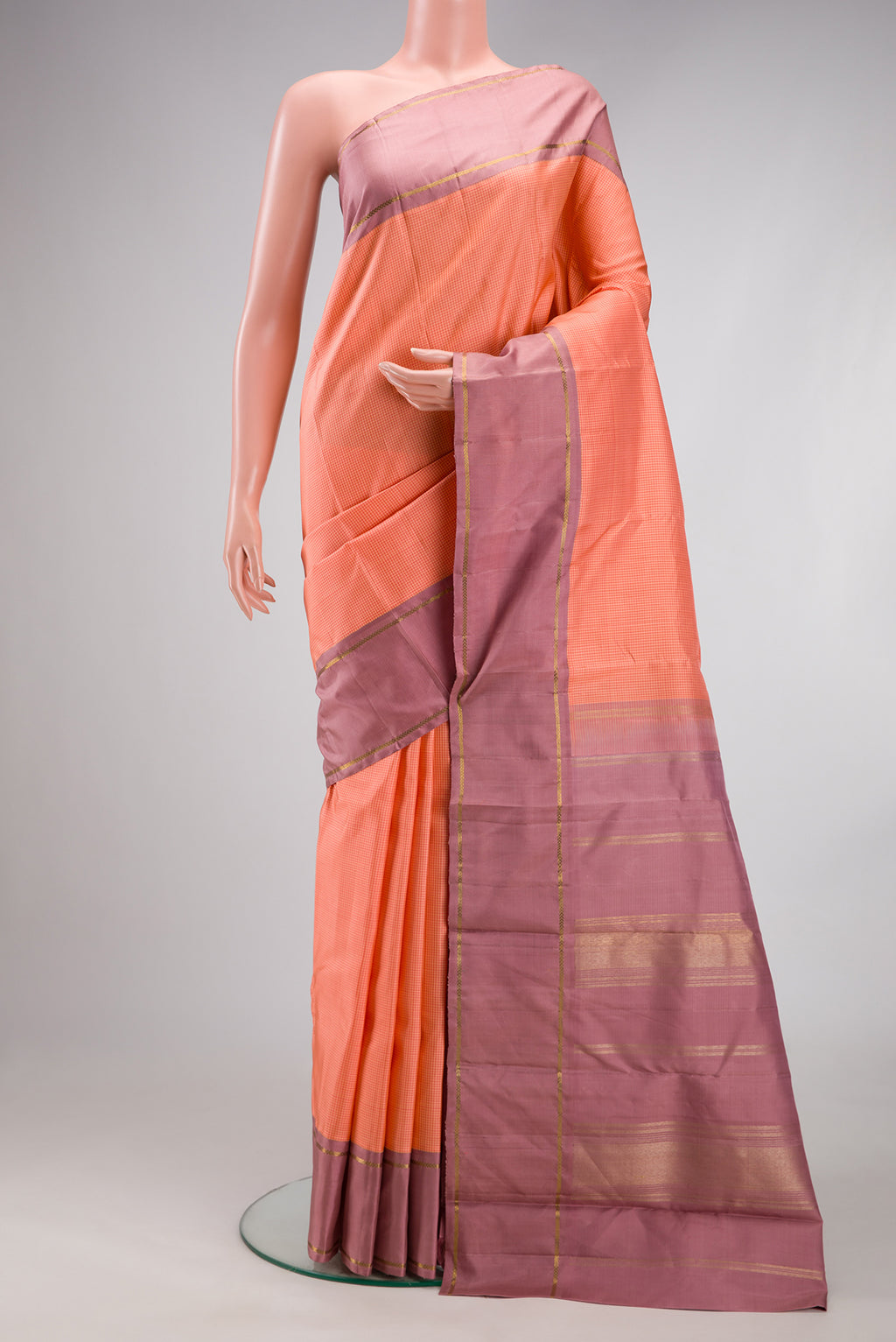 Peach Kanjivaram Silk Saree with Zari Butta on the body and Plain Border.  displayed on a mannequin