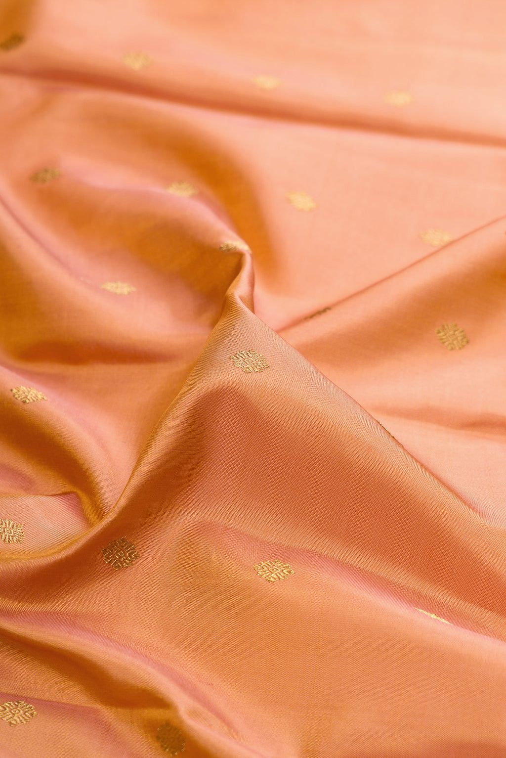 Close up of Pure Silk Pure Zari Golden Peach Kanjivaram Saree with Zari Butta on the body and Fancy Border.  displaying folds