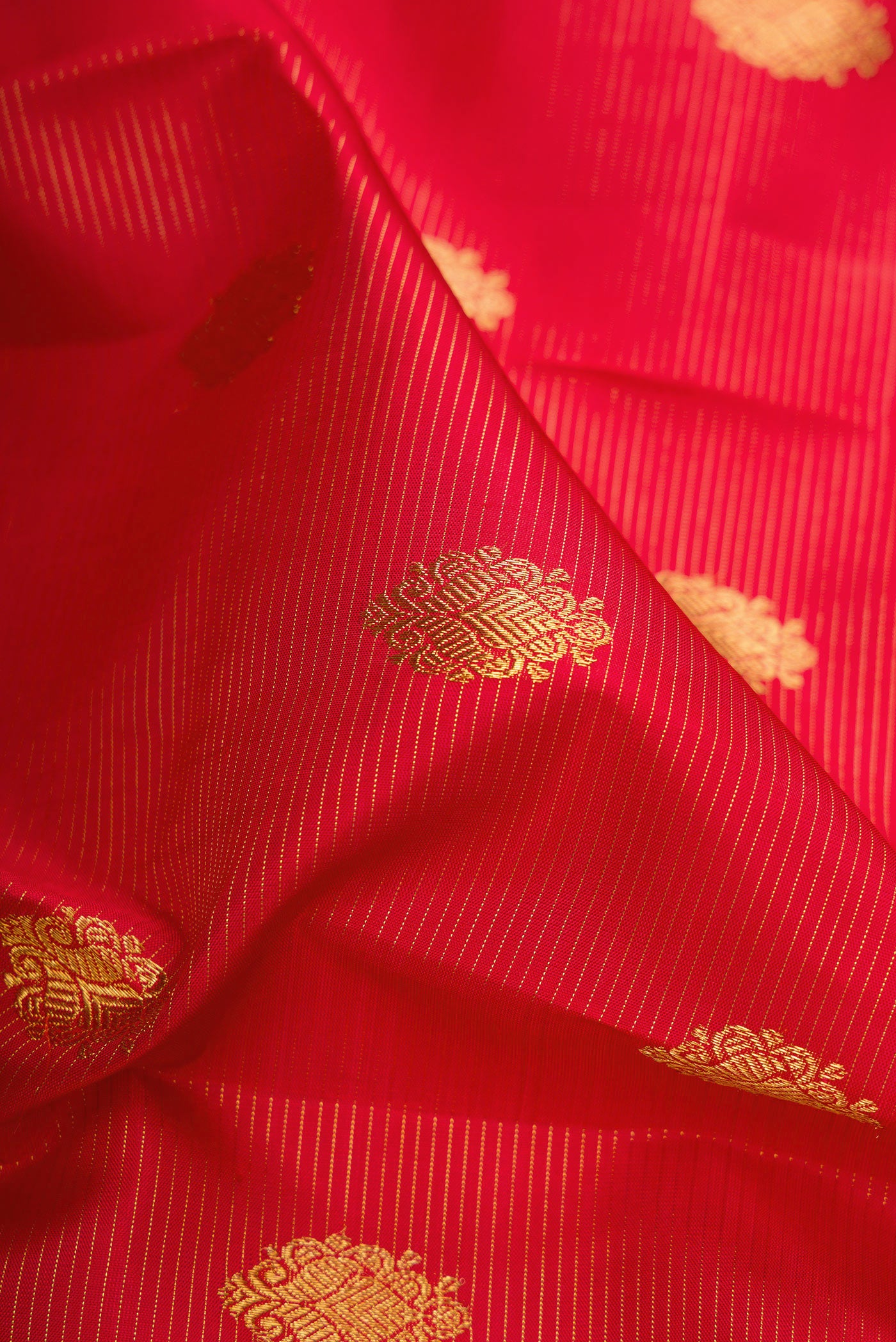 Close up of Pure Silk Pure Zari Deep Red Kanjivaram Saree with Stripes on the body and Zari Border.  displaying folds