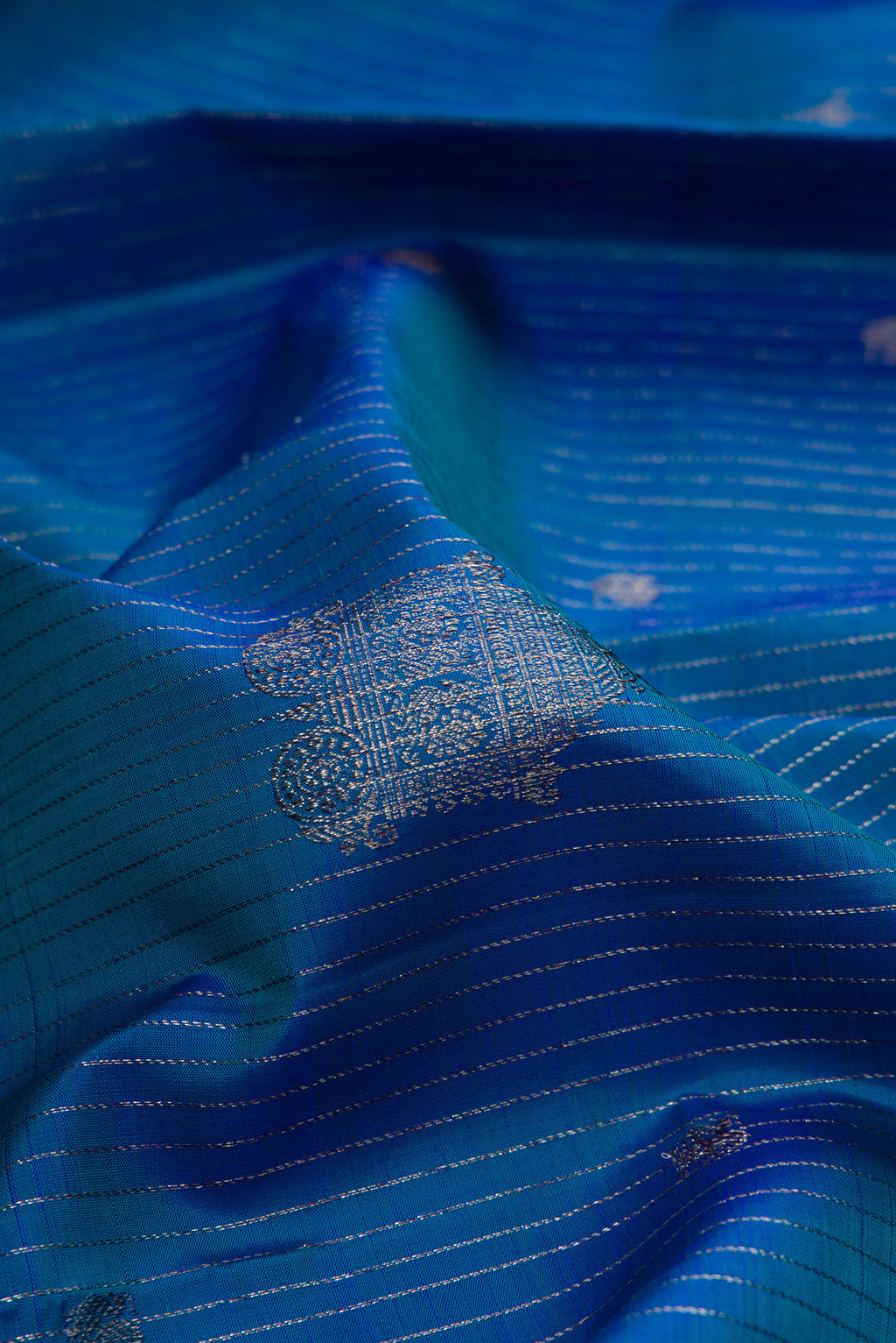 Close up of Peacock Blue Dual Tone Kanjivaram Silk Saree with Stripes on the body and Without Border.  displaying folds