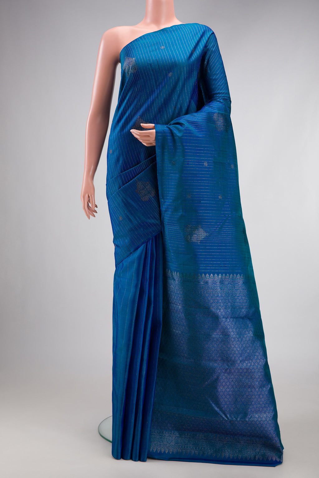 Peacock Blue Dual Tone Kanjivaram Silk Saree with Stripes on the body and Without Border.  displayed on a mannequin