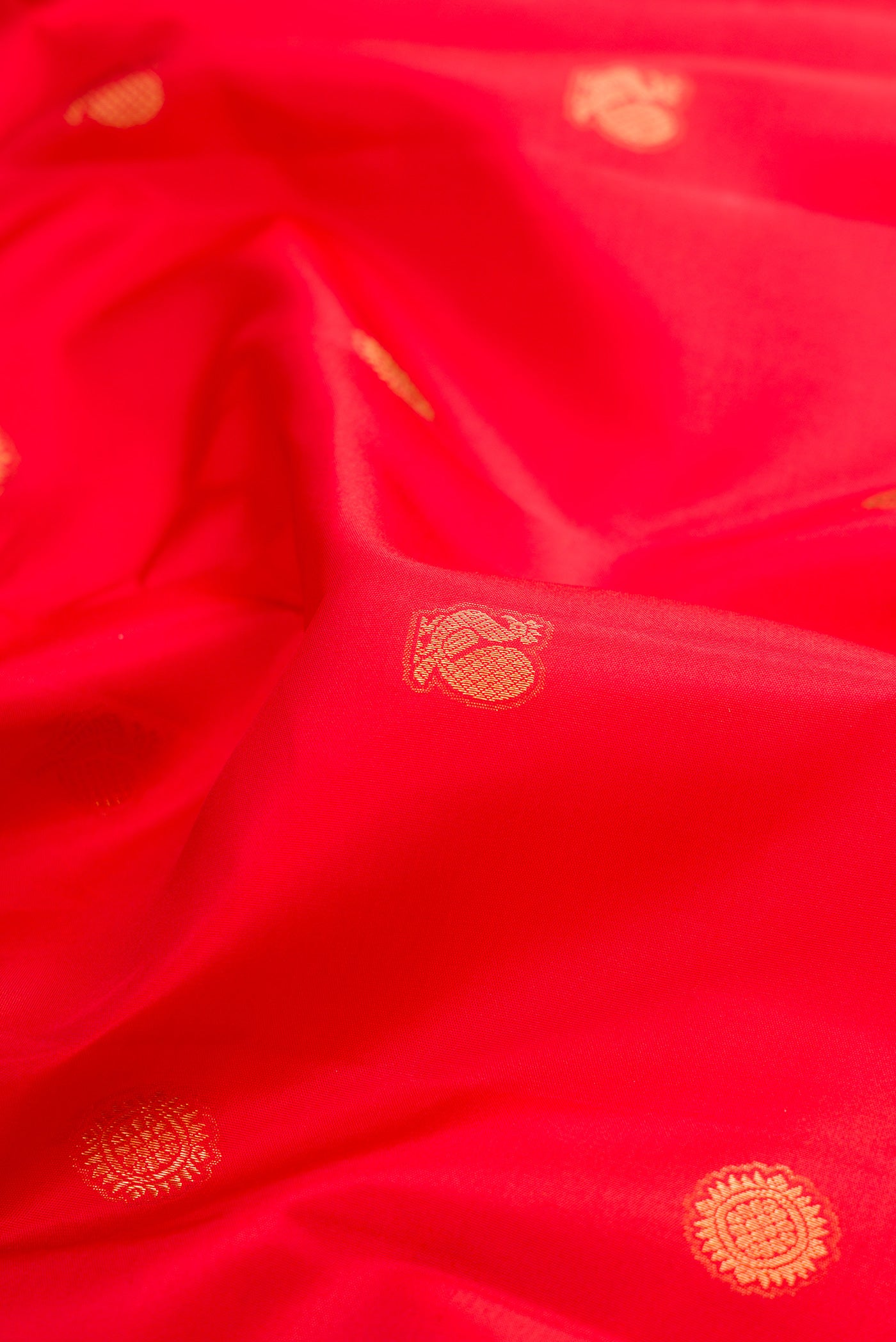 Close up of Red Kanchipuram Silk Saree with Zari Butta on the body and Fancy Border.  displaying folds