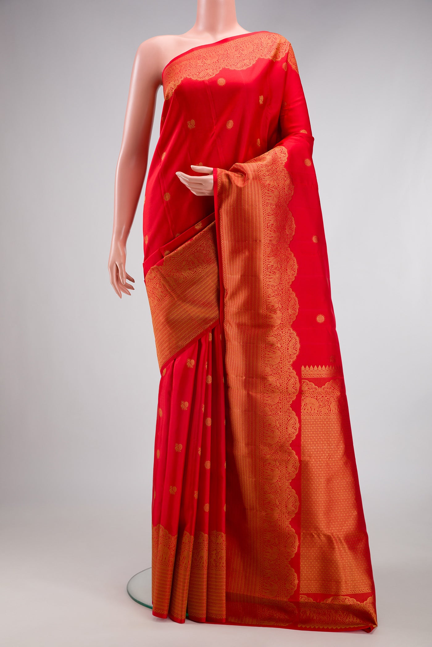 Red Kanchipuram Silk Saree with Zari Butta on the body and Fancy Border.  displayed on a mannequin