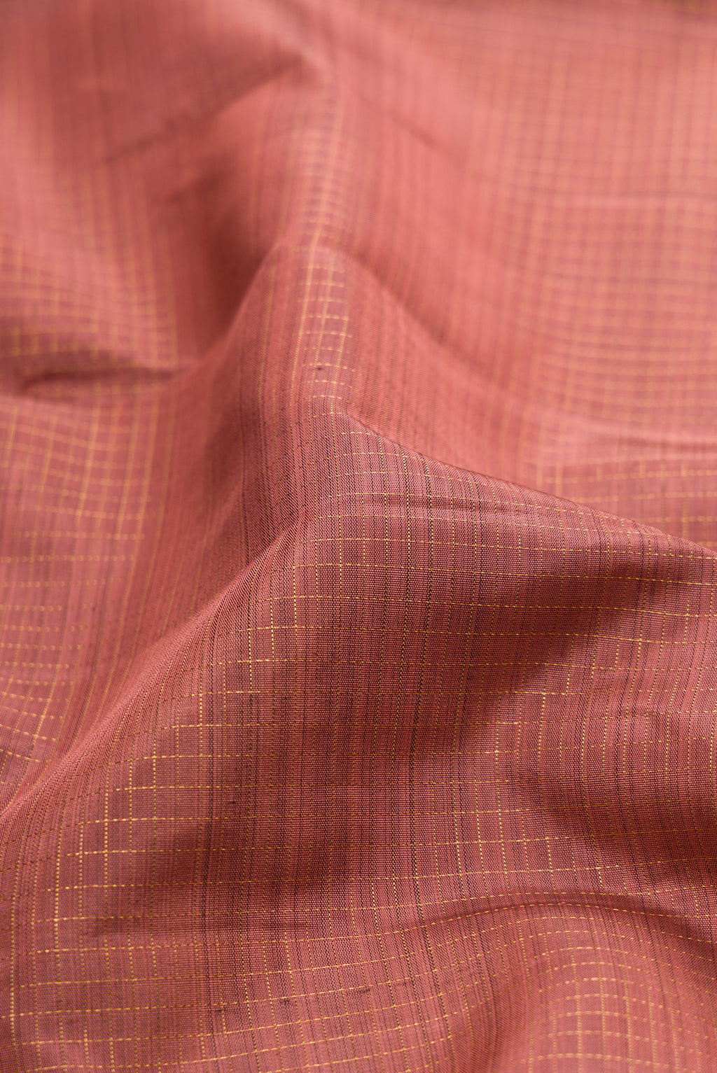 Close up of Rose Gold Kanjivaram Silk Saree with Checked design on the body and Fancy Border.  displaying folds