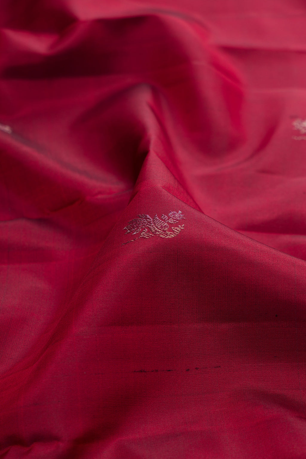 Close up of Maroon Kanchipuram Silk Saree with Zari Butta on the body and Fancy Border.  displaying folds