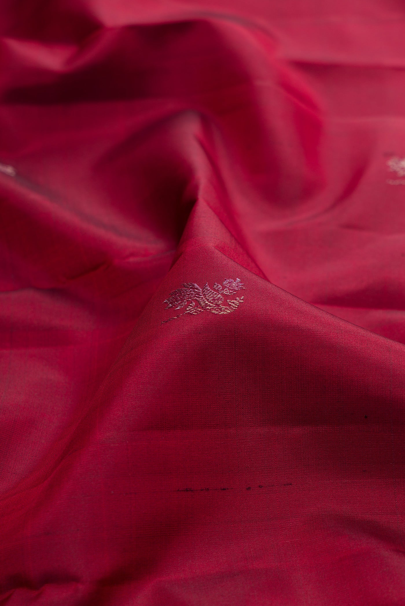 Close up of Maroon Kanchipuram Silk Saree with Zari Butta on the body and Fancy Border.  displaying folds