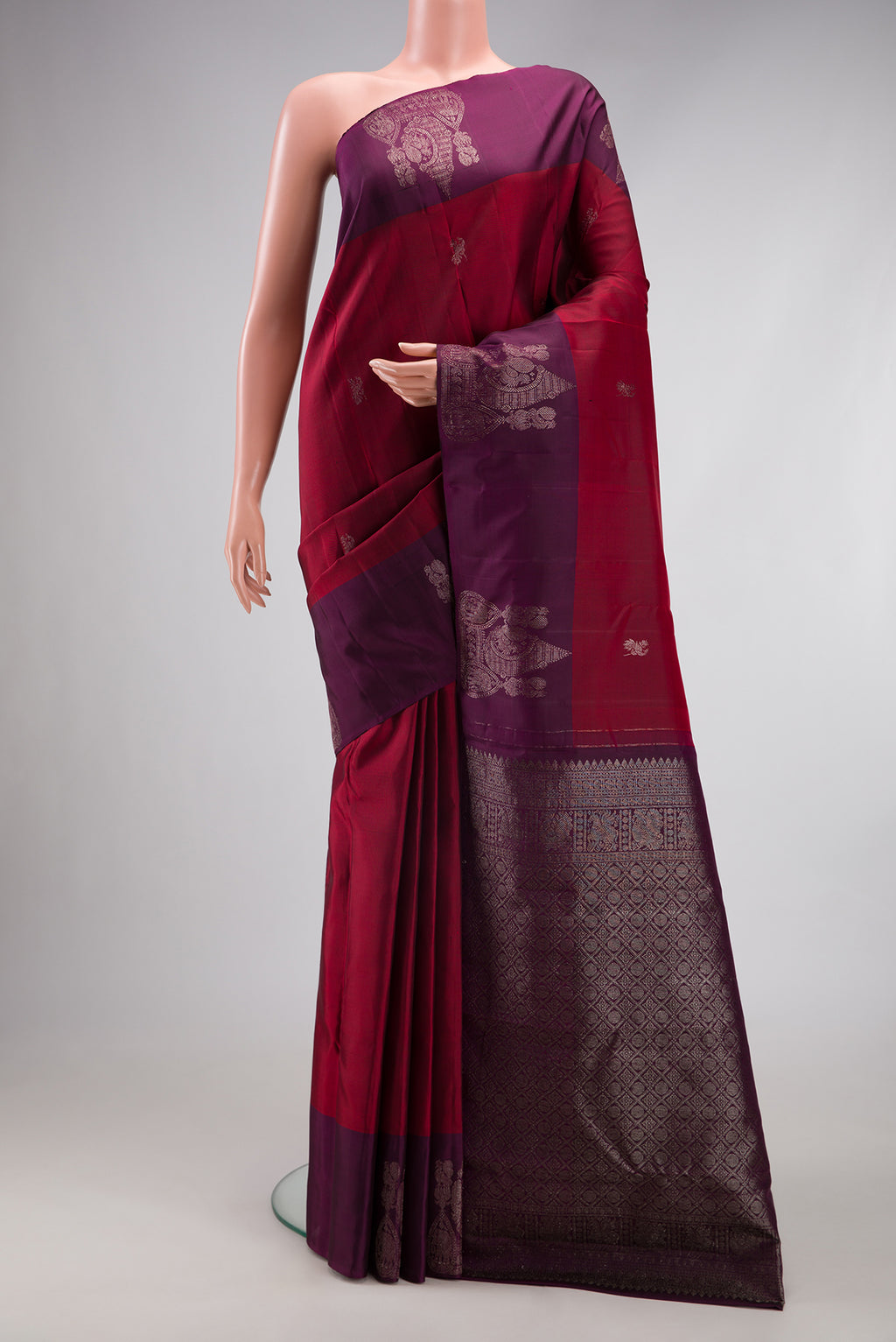 Maroon Kanchipuram Silk Saree with Zari Butta on the body and Fancy Border.  displayed on a mannequin