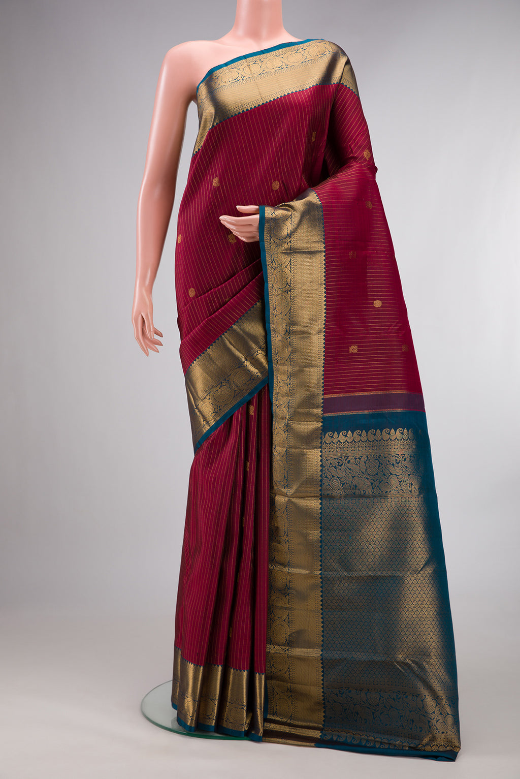 Pure Silk Red Kanjivaram Saree with Stripes on the body and Zari Border.  displayed on a mannequin