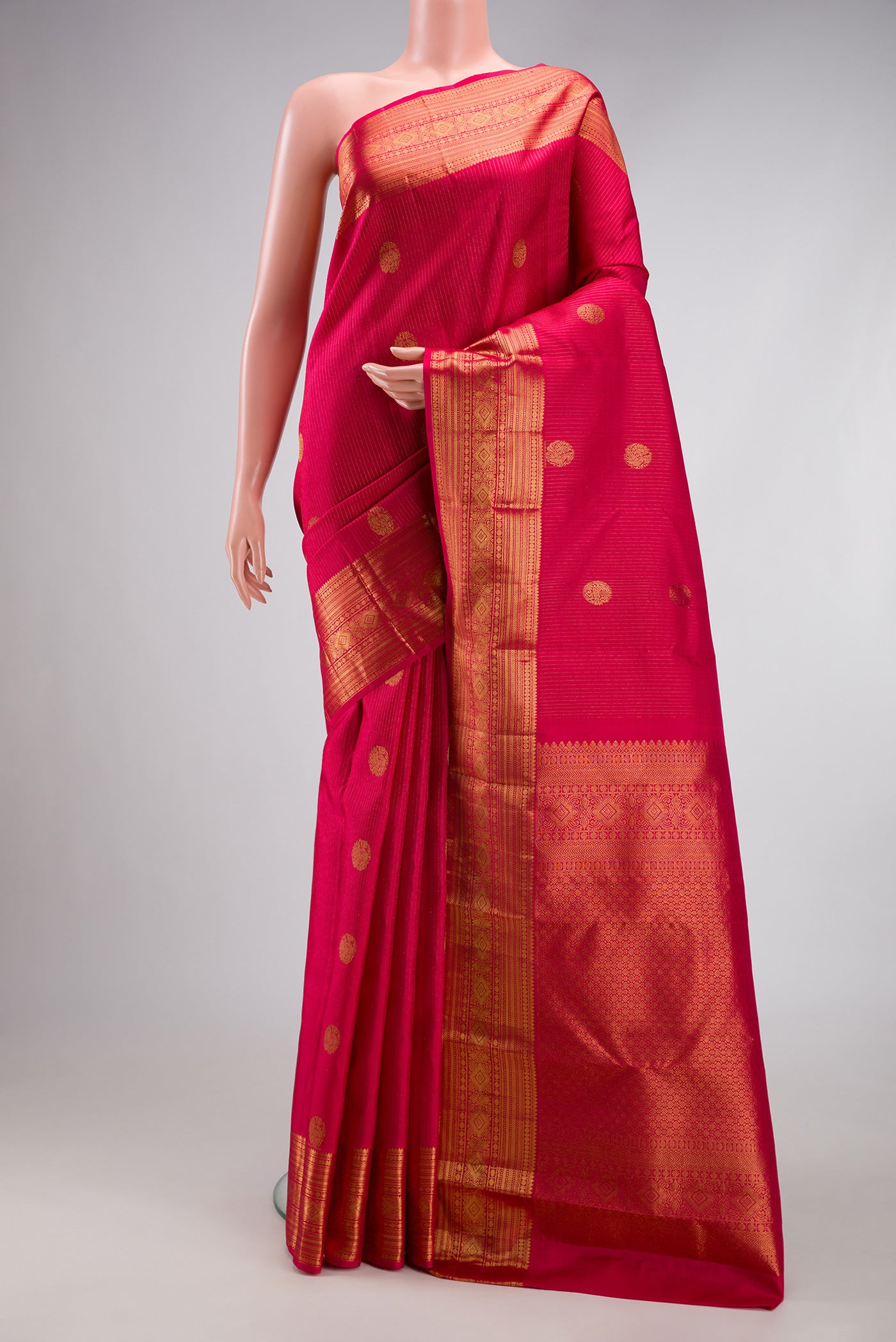 Dark Pink Kanjivaram Silk Saree with Stripes on the body and Zari Border.  displayed on a mannequin