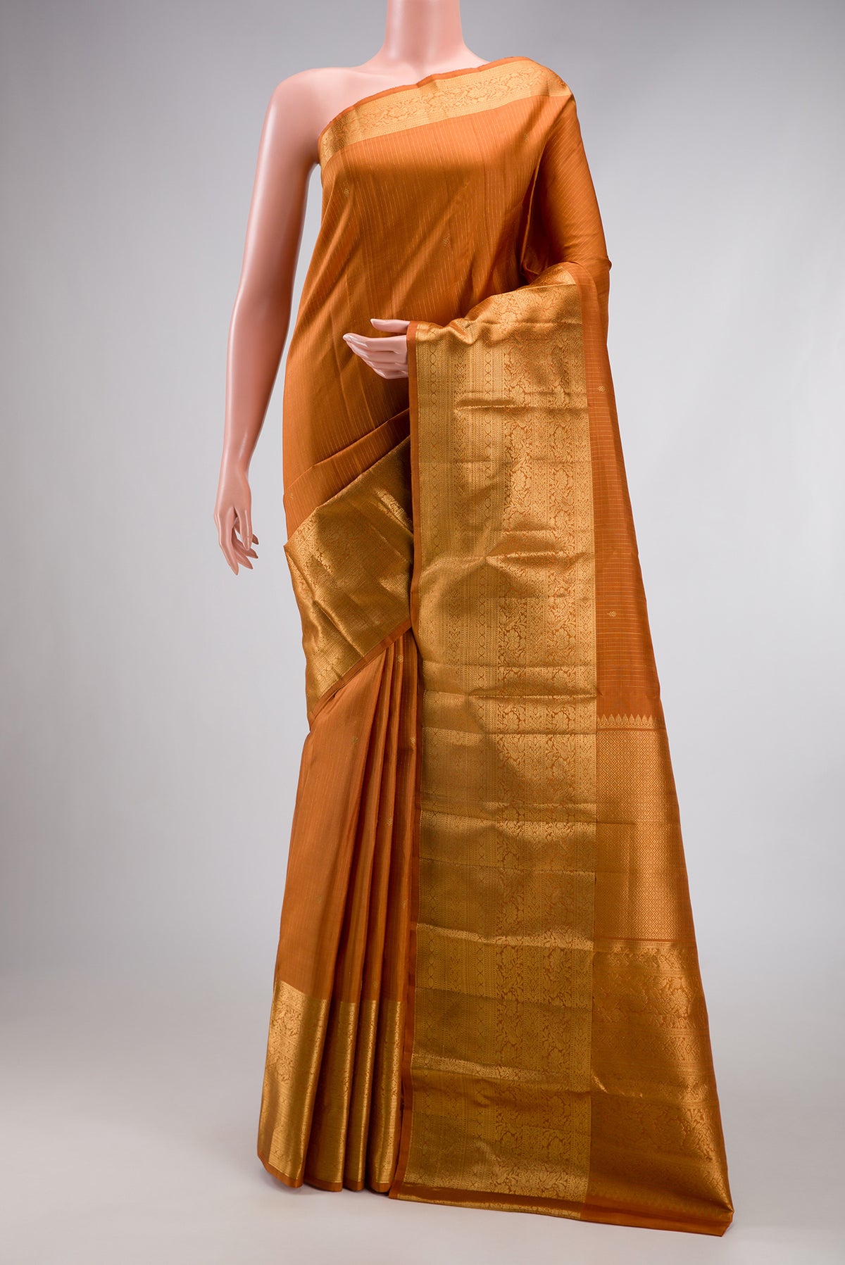 Mustard Kanjivaram Silk Saree with Stripes on the body and Zari Border.  displayed on a mannequin