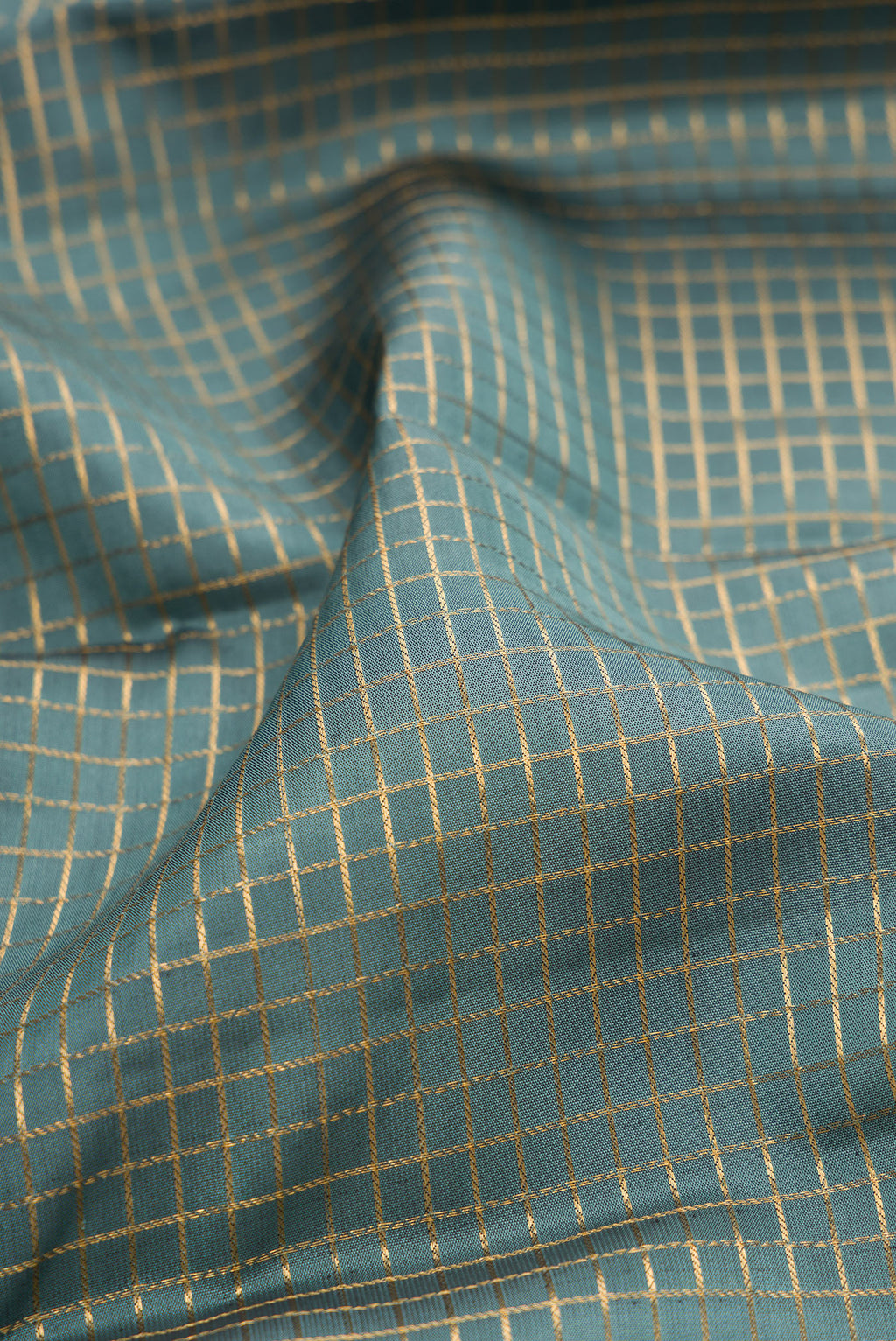 Close up of Grey Kanjivaram Silk Saree with Checked design on the body and Fancy Border.  displaying folds