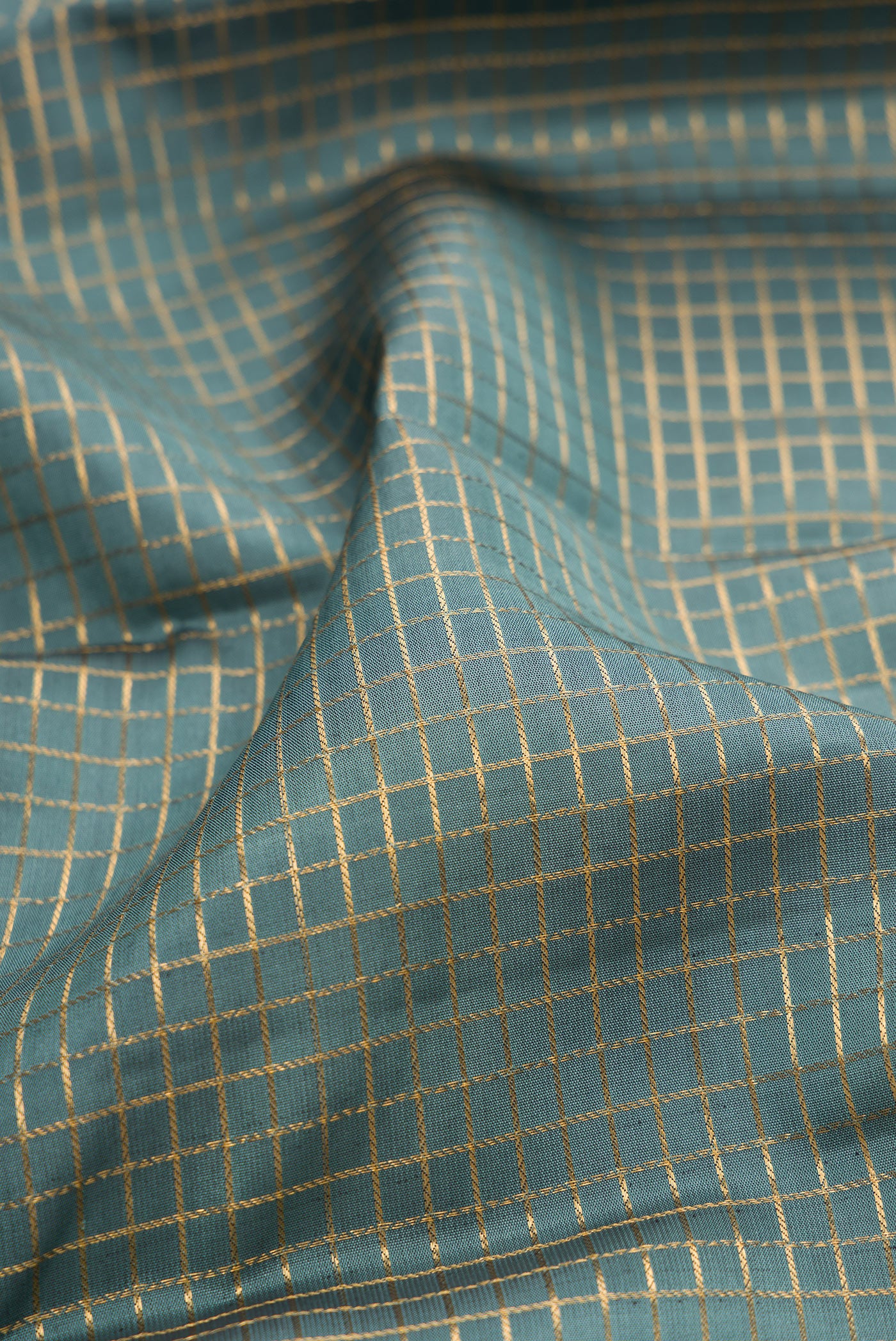 Close up of Grey Kanjivaram Silk Saree with Checked design on the body and Fancy Border.  displaying folds