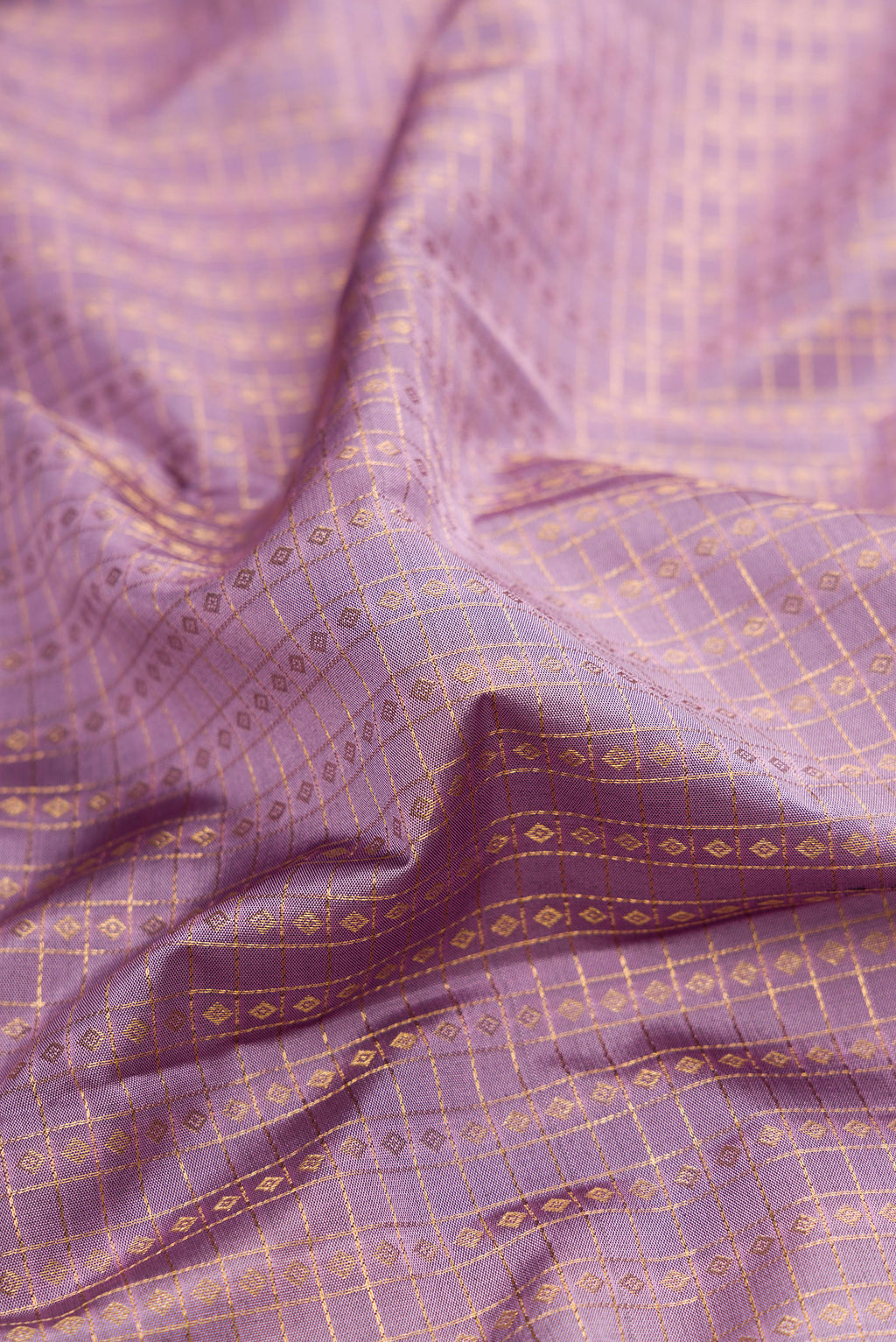 Close up of Lavender Dual Tone Kanjivaram Silk Saree with Checked design on the body and Fancy Border.  displaying folds