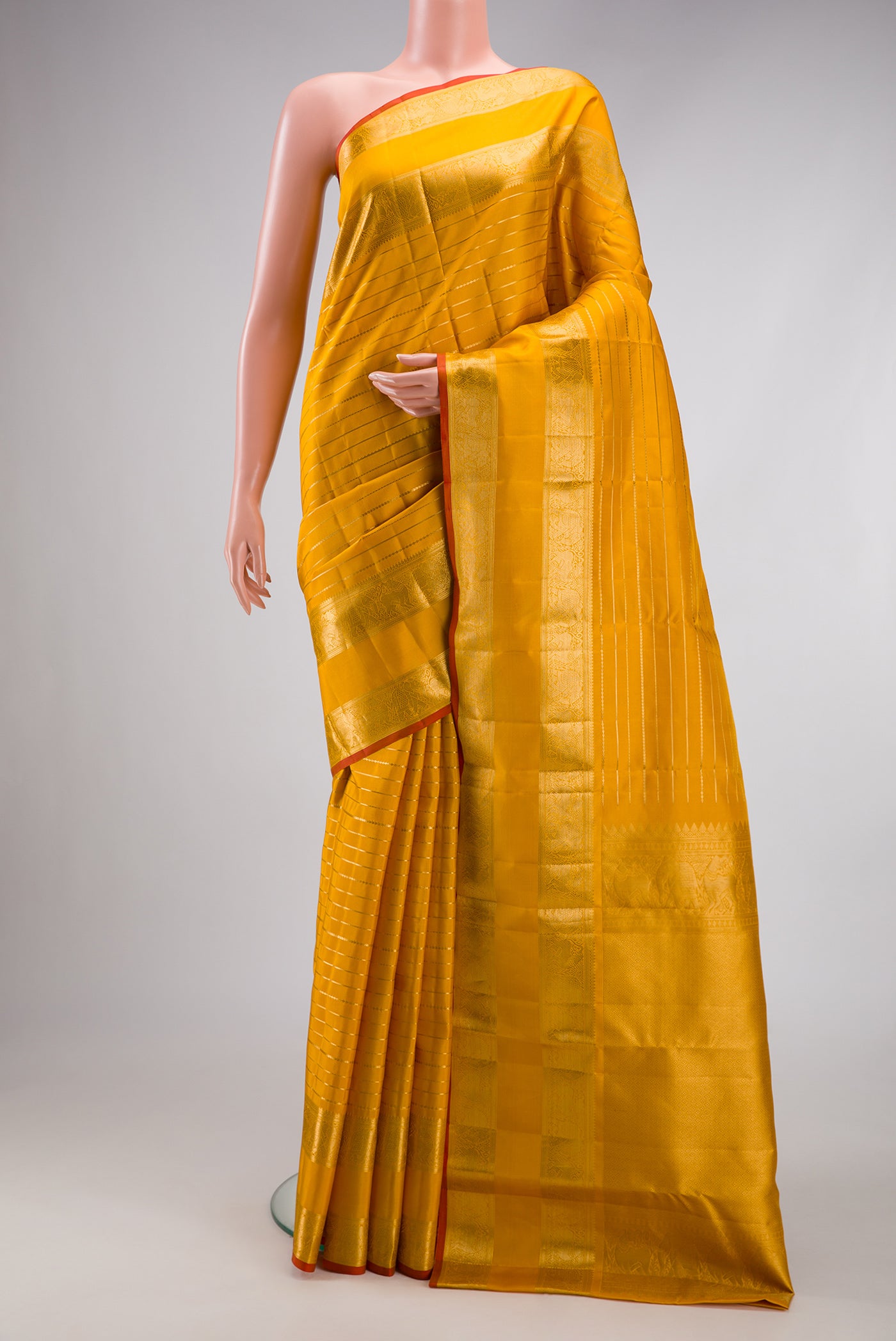 Mustard Kanjivaram Silk Saree with Veldhari on the body and Fancy Border.  displayed on a mannequin