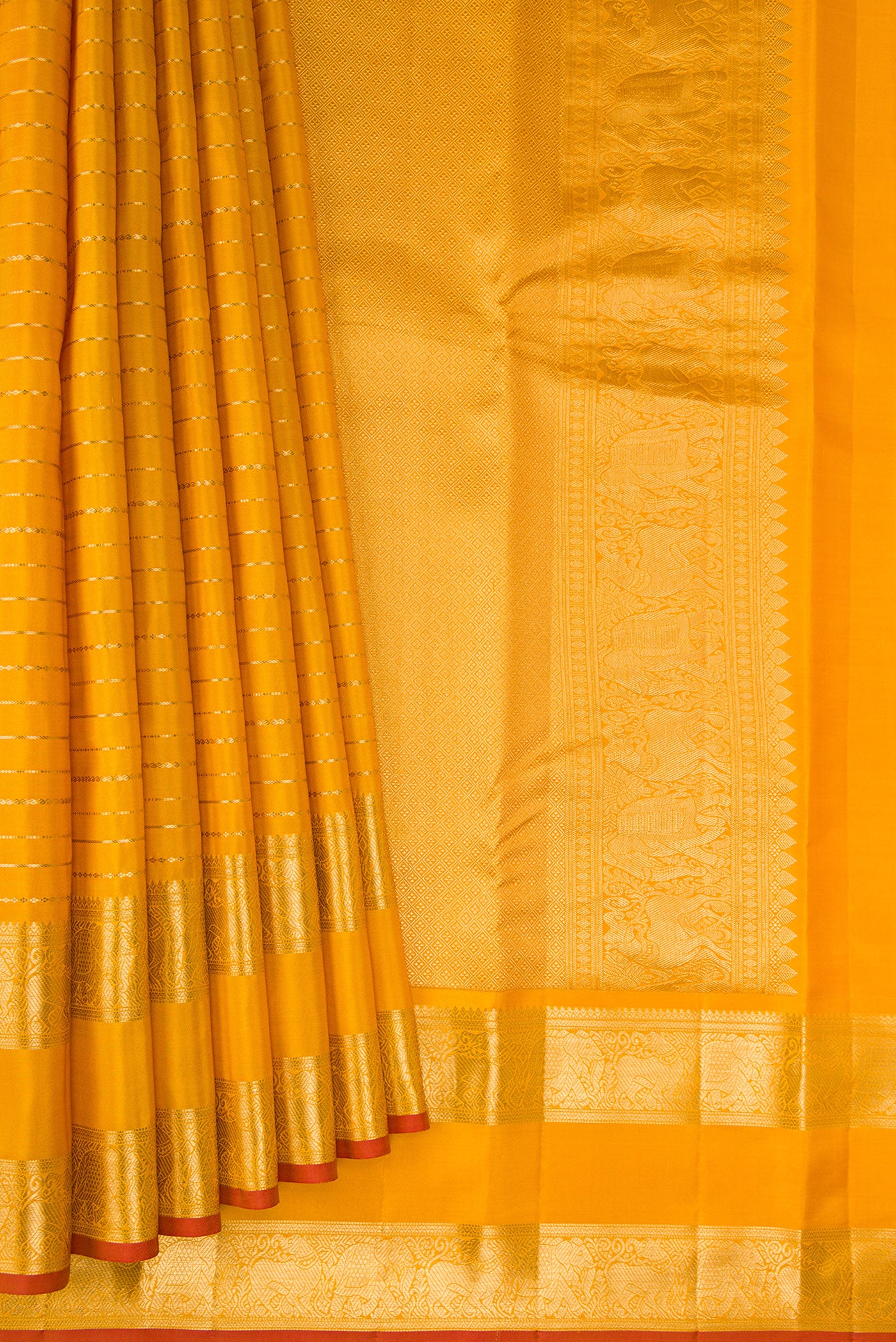 Pleats and pallu of Mustard Kanjivaram Silk Saree with Veldhari on the body and Fancy Border. 