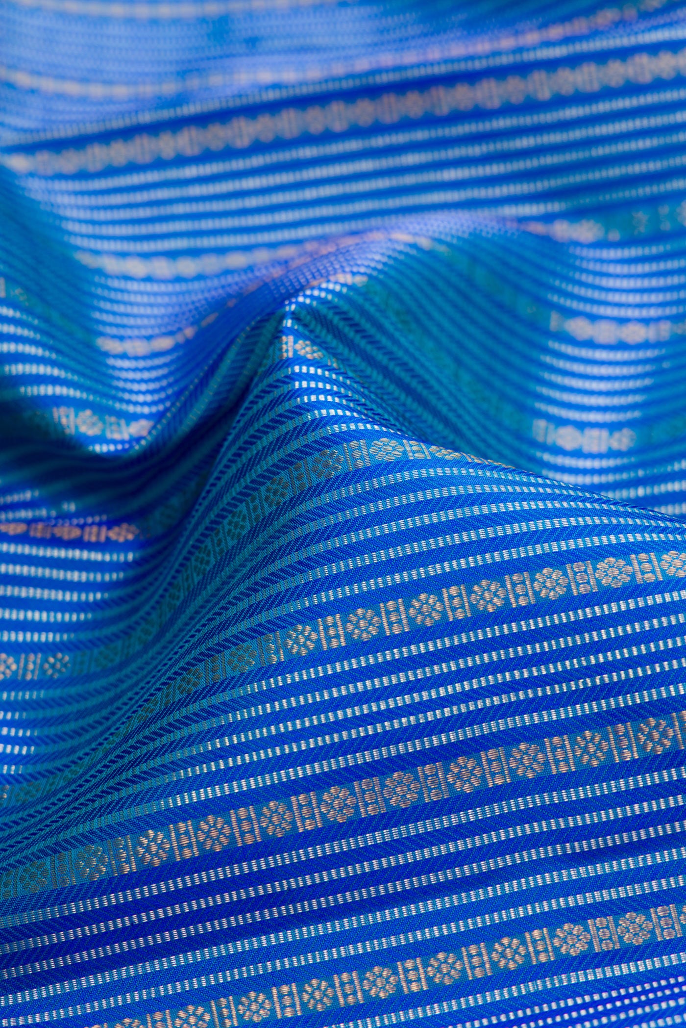 Close up of Peacock Blue Dual Tone Kanjivaram Silk Saree with Stripes on the body and Zari Border.  displaying folds