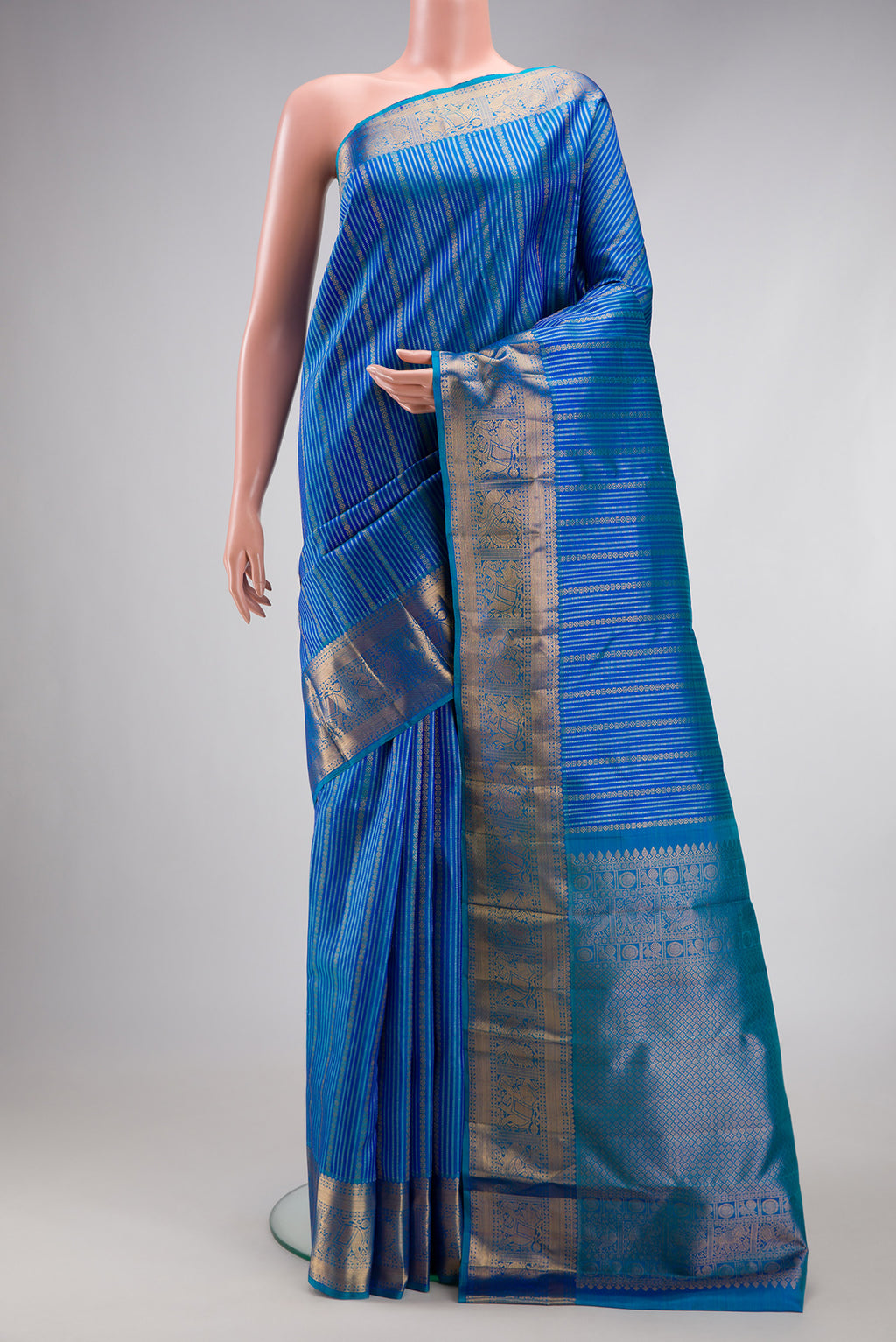 Peacock Blue Dual Tone Kanjivaram Silk Saree with Stripes on the body and Zari Border.  displayed on a mannequin