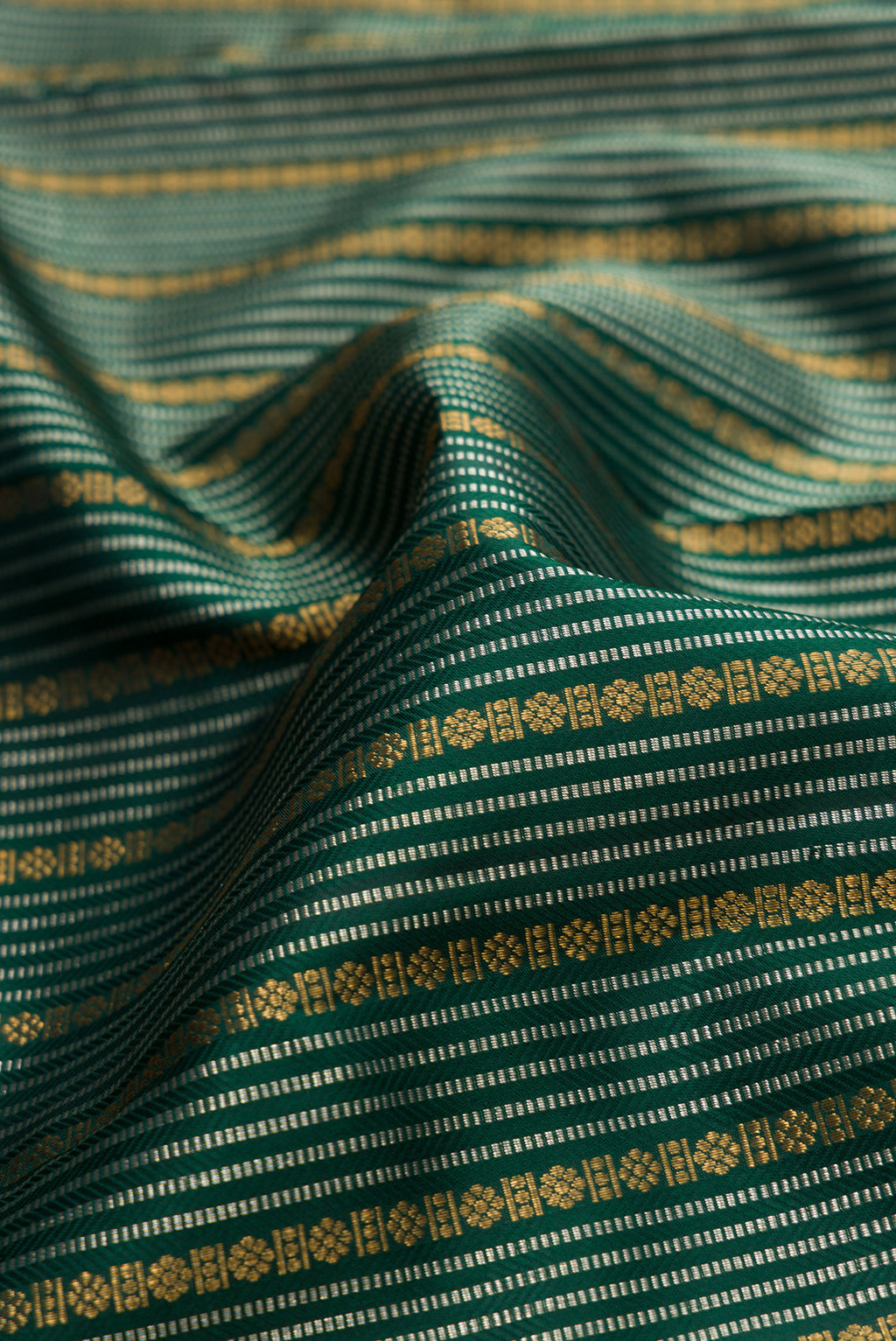 Close up of Bottle Green Kanjivaram Silk Saree with Stripes on the body and Fancy Border.  displaying folds