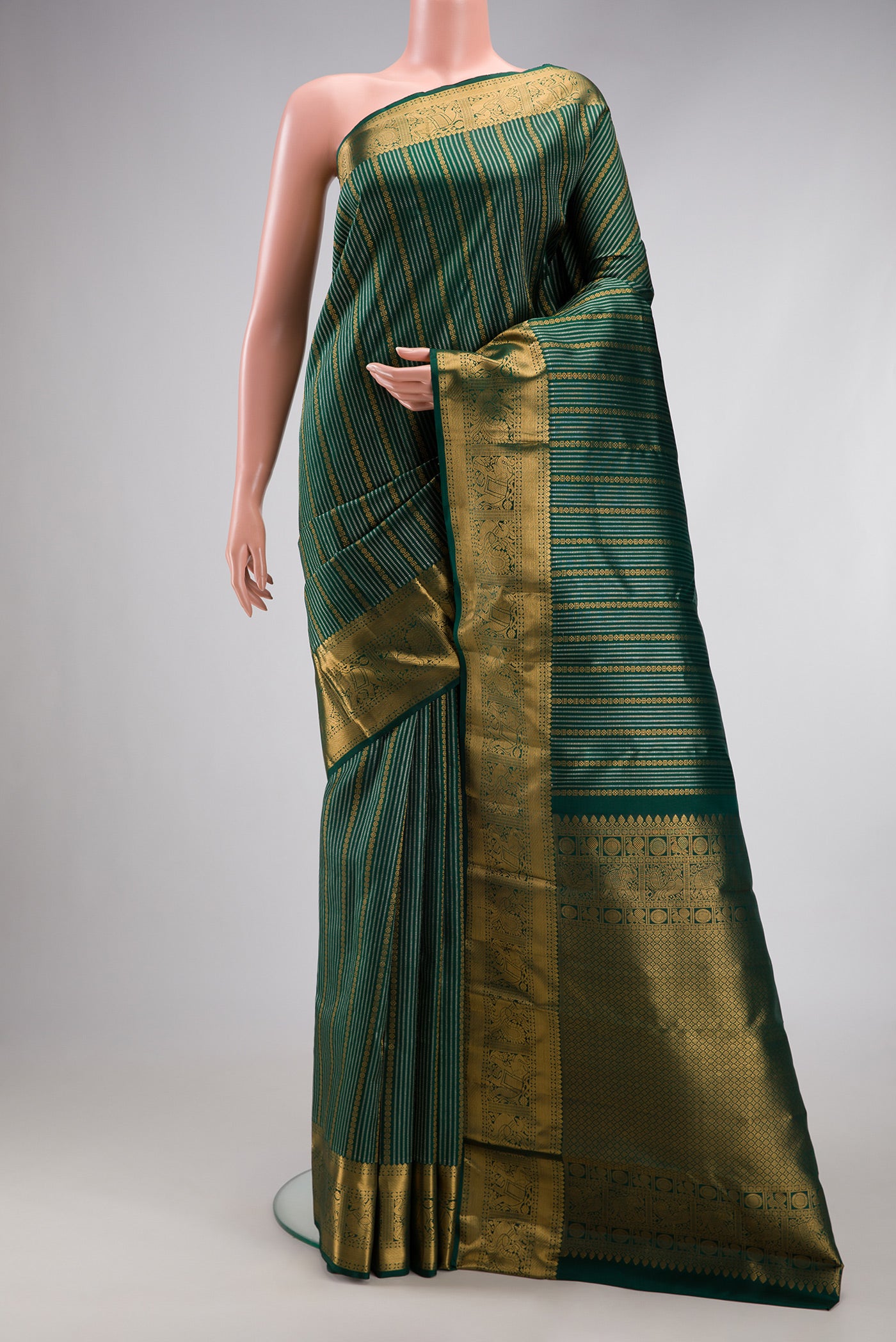 Bottle Green Kanjivaram Silk Saree with Stripes on the body and Fancy Border.  displayed on a mannequin