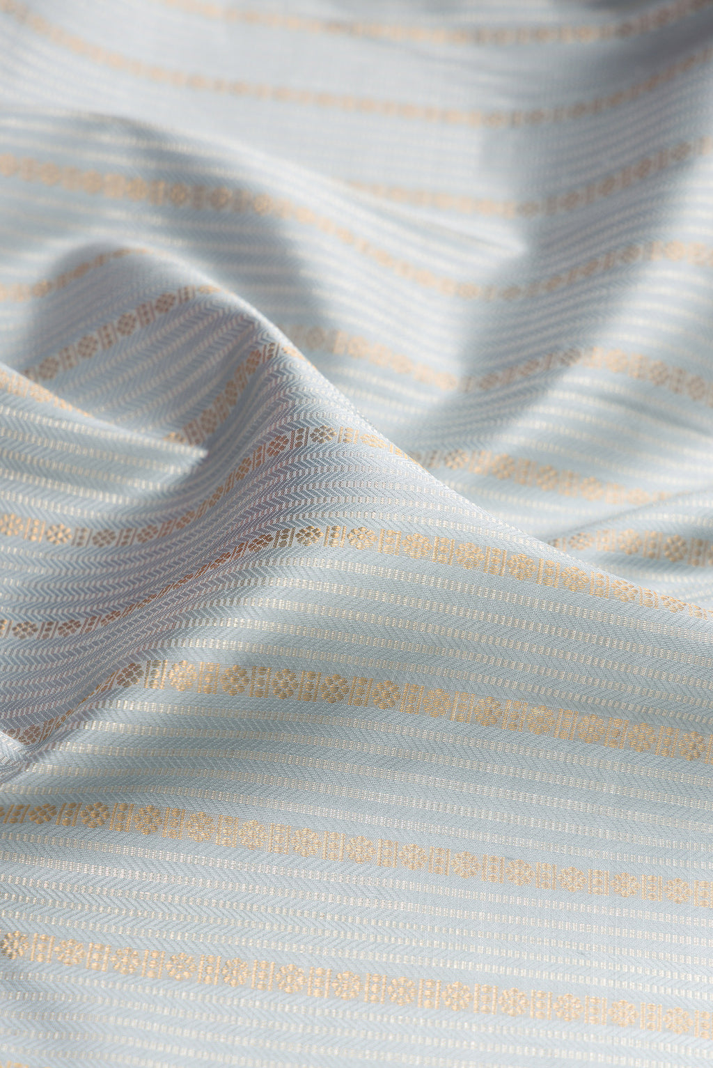 Close up of Grey Kanjivaram Silk Saree with Stripes on the body and Zari Border.  displaying folds