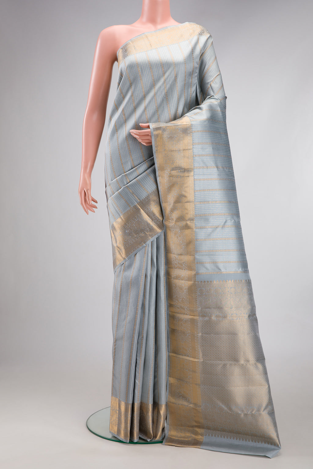 Grey Kanjivaram Silk Saree with Stripes on the body and Zari Border.  displayed on a mannequin