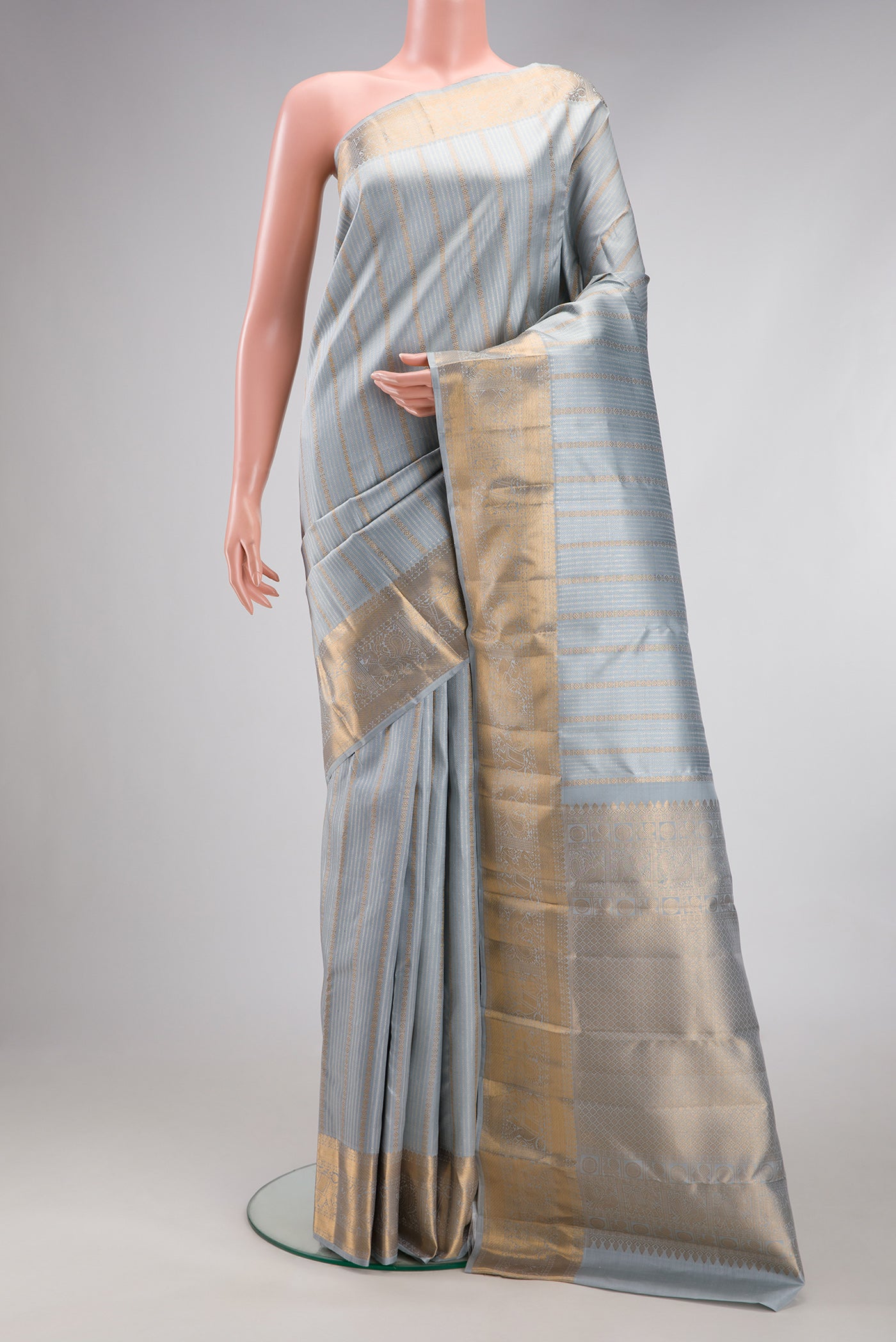 Grey Kanjivaram Silk Saree with Stripes on the body and Zari Border.  displayed on a mannequin