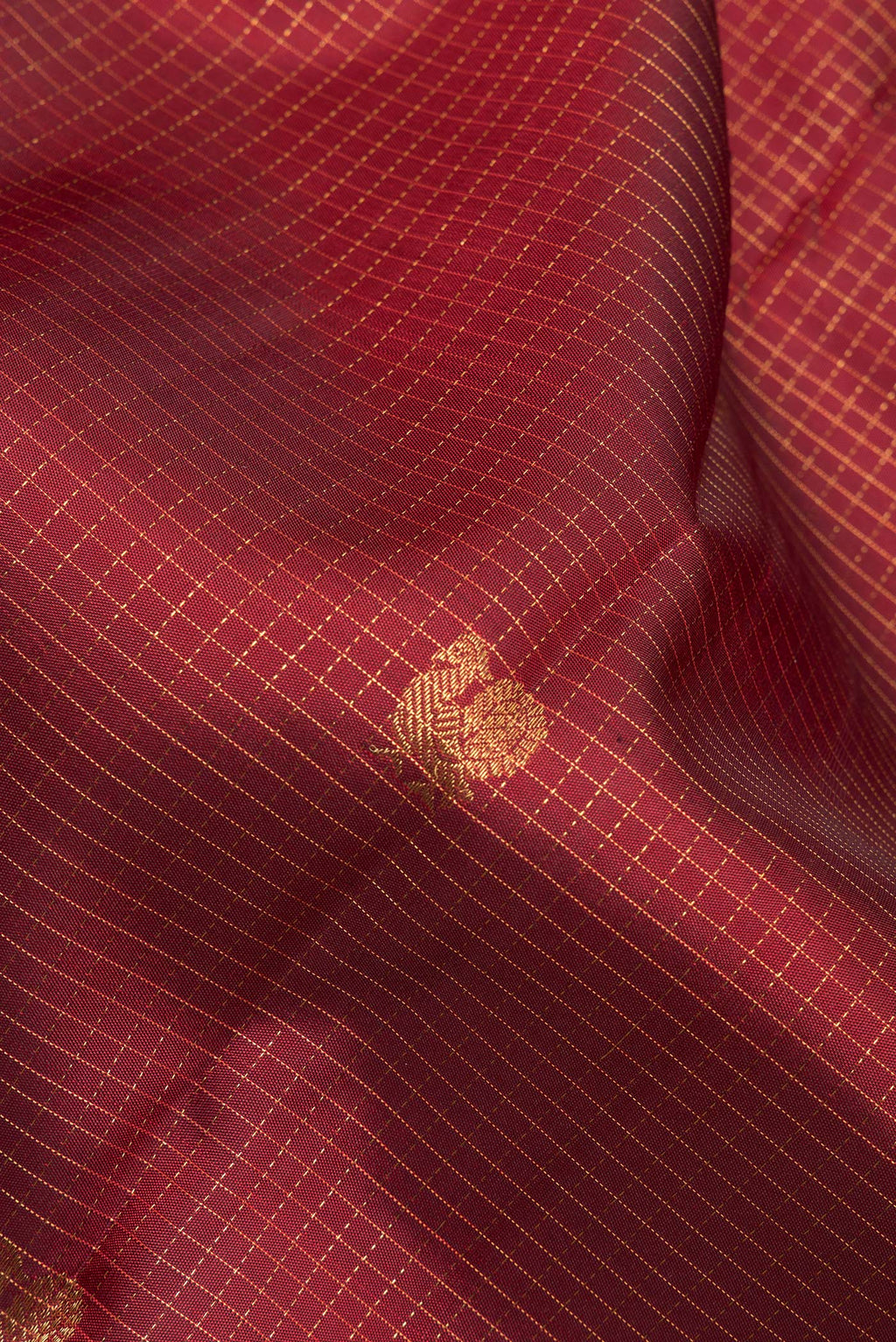 Close up of Pure Silk Maroon Kanjivaram Saree with Checked design on the body and Zari Border.  displaying folds
