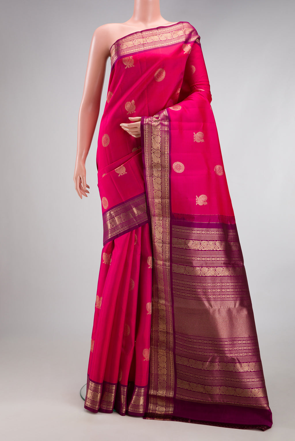 Dark Pink Kanjivaram Silk Saree with Zari Butta on the body and Zari Border.  displayed on a mannequin