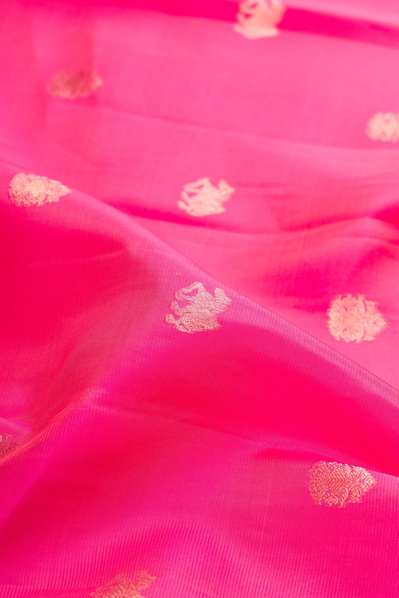 Close up of Pink Kanjivaram Silk Saree with Zari Butta on the body and Zari Border.  displaying folds