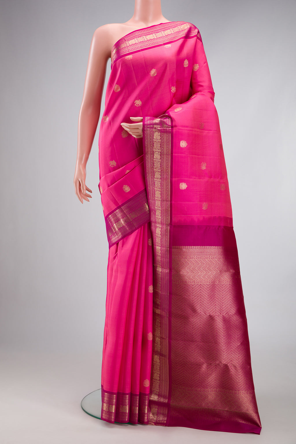 Pink Kanjivaram Silk Saree with Zari Butta on the body and Zari Border.  displayed on a mannequin