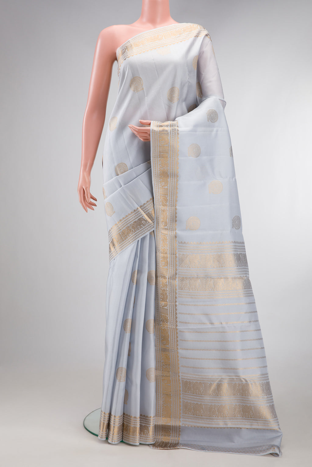 Grey Kanjivaram Silk Saree with Zari Butta on the body and Zari Border.  displayed on a mannequin