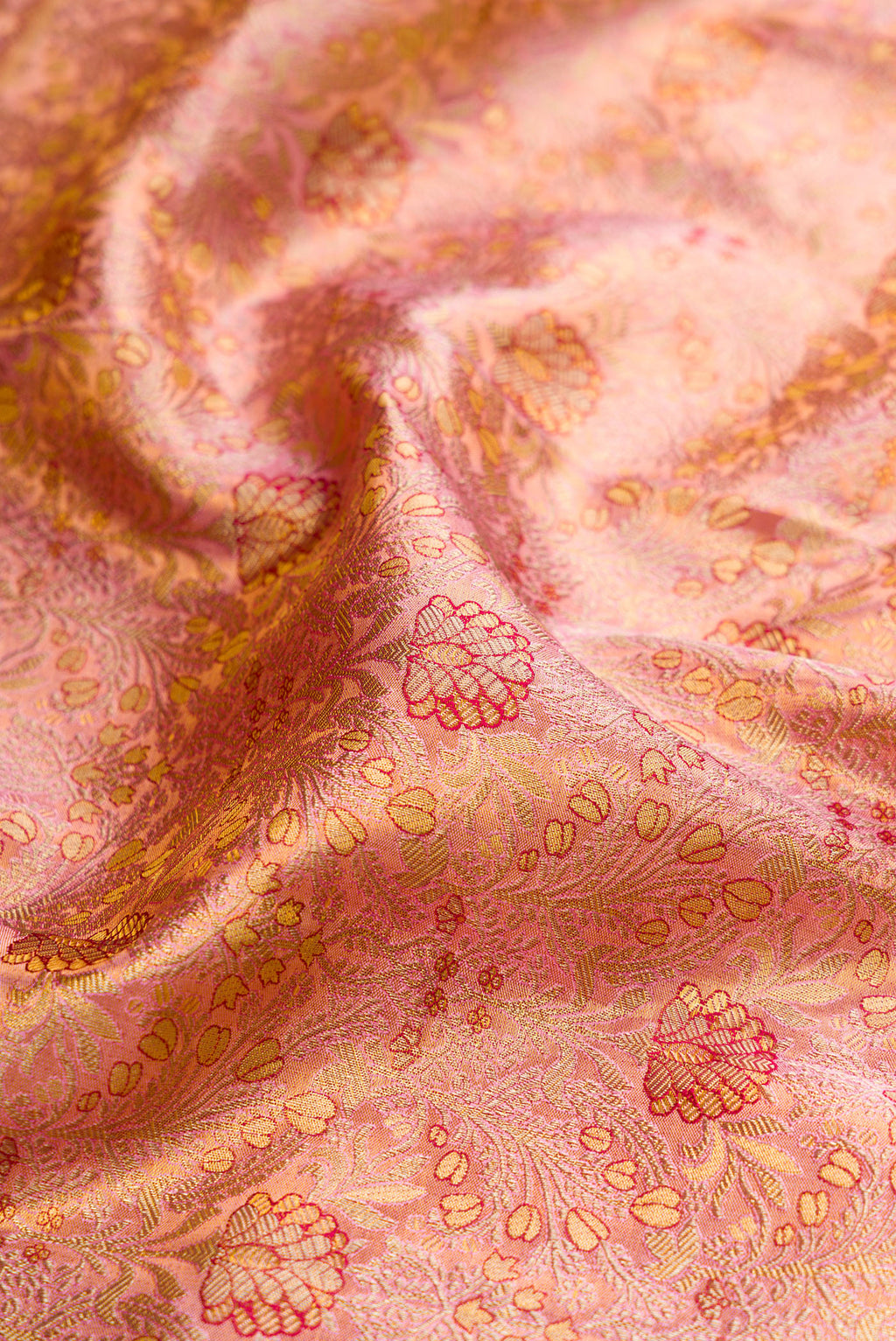 Close up of Rose Gold Dual Tone Kanjivaram Tissue Silk Saree with Zari Brocade on the body and Fancy Border.  displaying folds