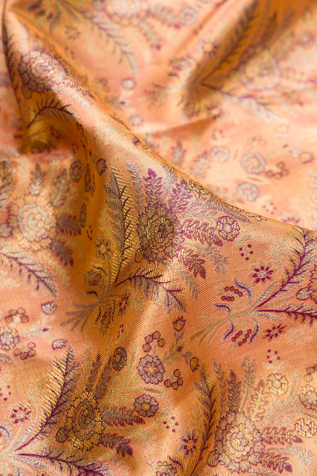 Close up of Golden Peach Dual Tone Kanjivaram Tissue Saree with Zari Brocade on the body and Fancy Border.  displaying folds