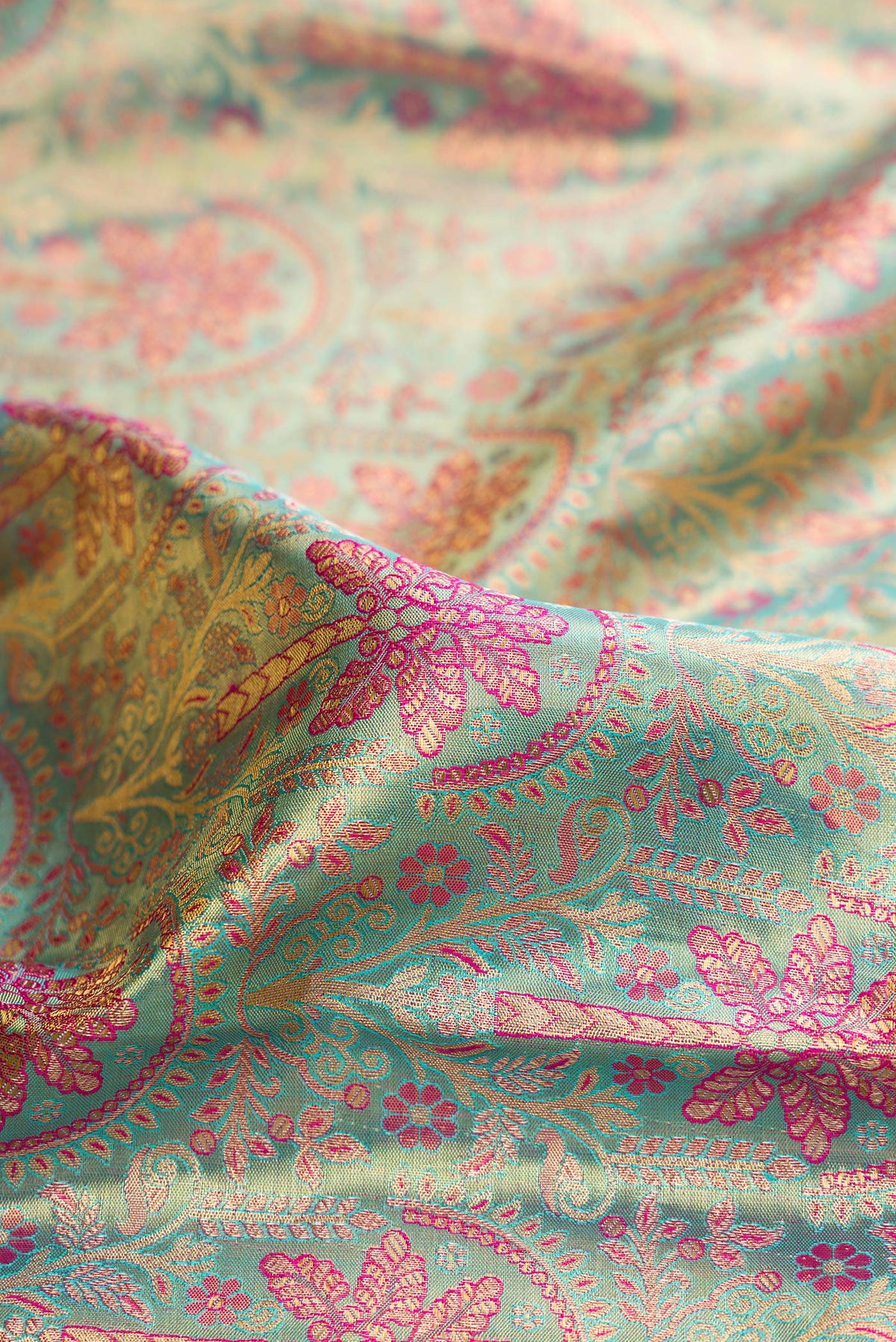 Close up of Sea Green Dual Tone Kanjivaram Tissue Saree with Zari Brocade on the body and Fancy Border.  displaying folds