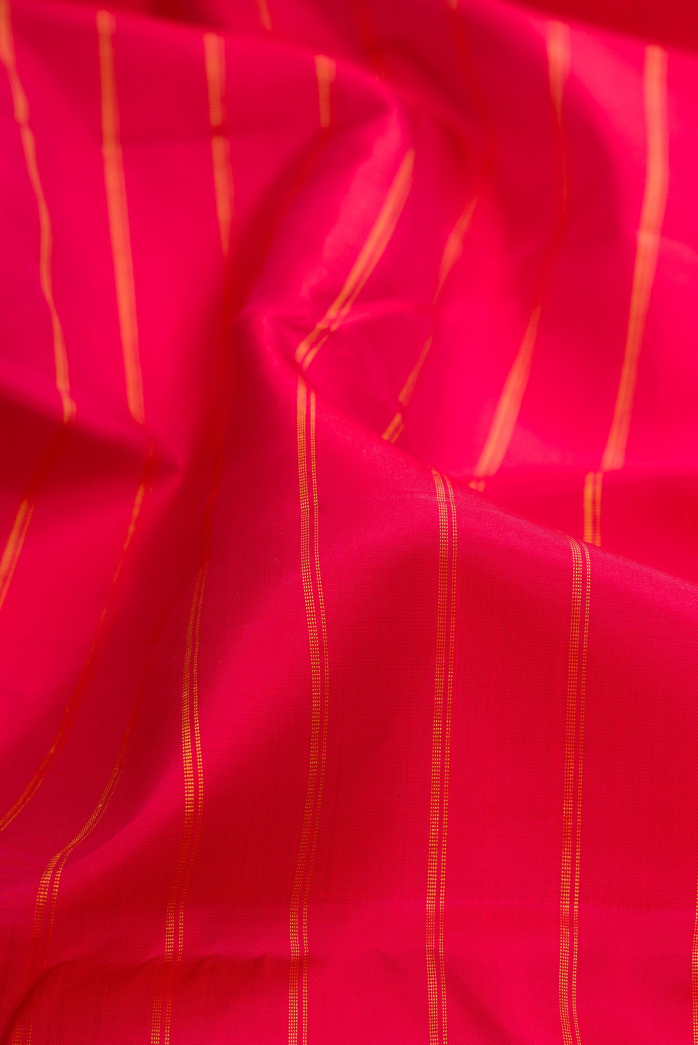 Close up of Maroon Kanchipuram Silk Saree with Stripes on the body and Zari Border.  displaying folds