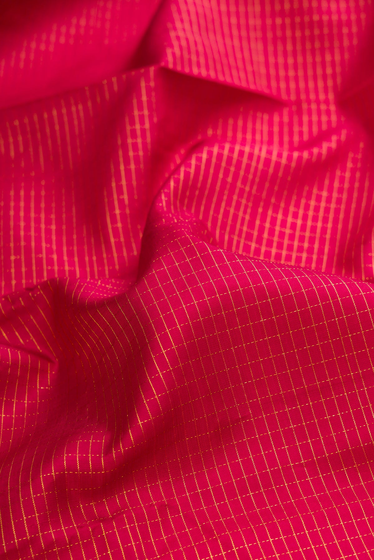 Close up of Pure Silk Maroon Kanchipuram Saree with Checked design on the body and Zari Border.  displaying folds