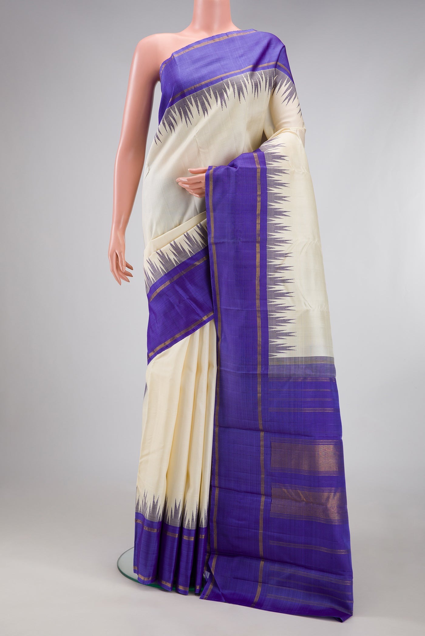 Off White Kanchipuram Silk Saree with Plain Body and Temple Border.  displayed on a mannequin