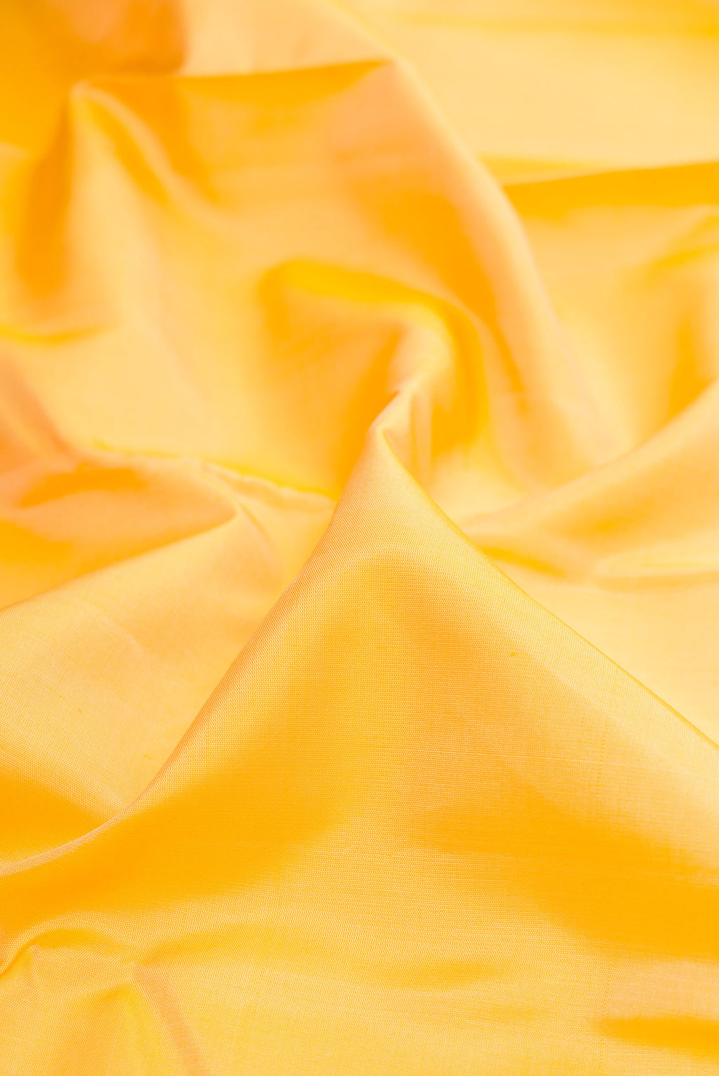 Close up of Yellow Kanchipuram Silk Saree with Plain Body and Plain Border.  displaying folds