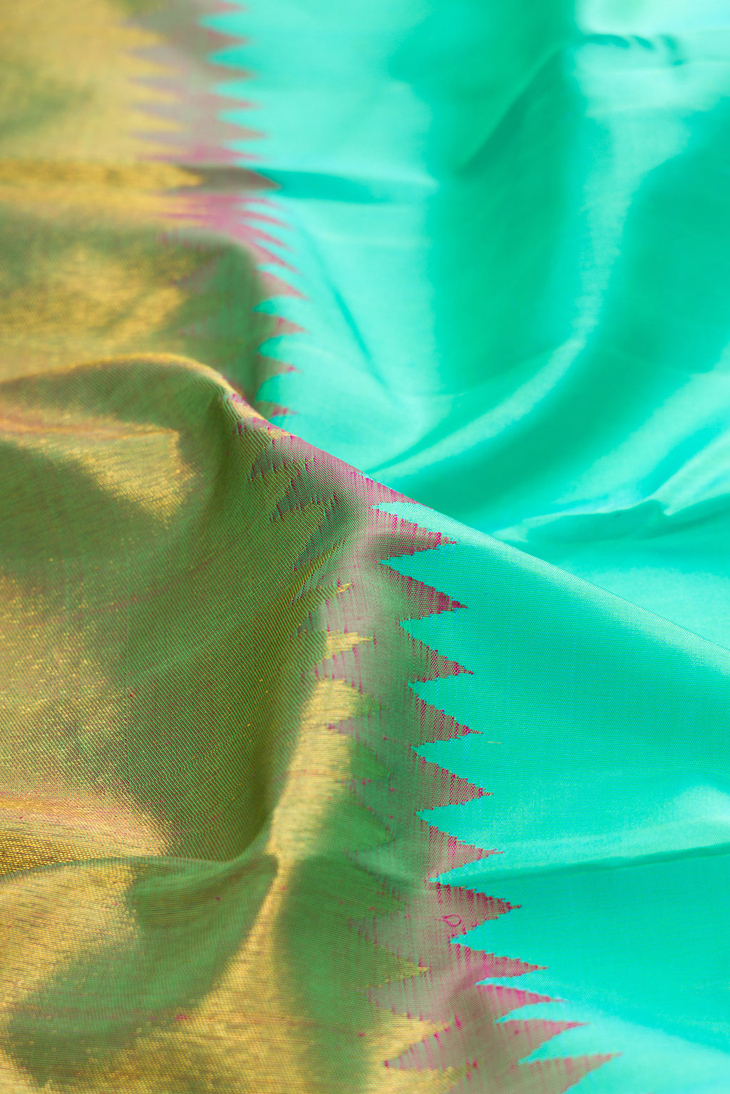 Close up of Sea Green Kanjivaram Silk Saree with Plain Body and Rising Temple Border.  displaying folds