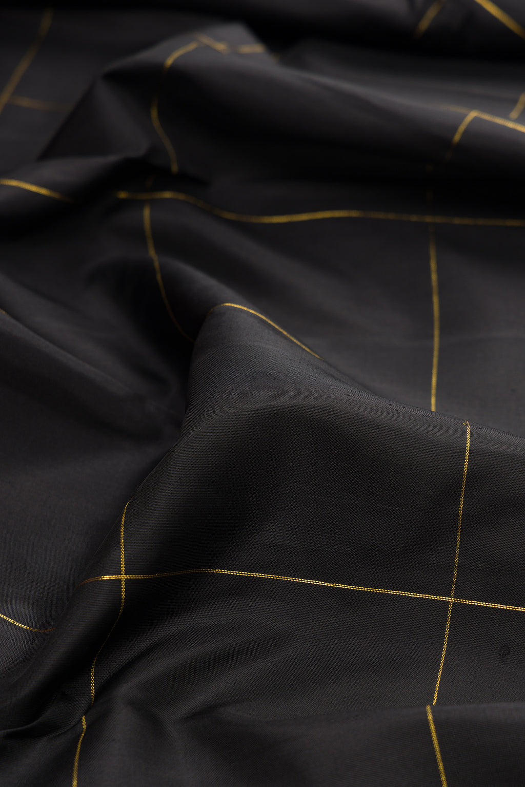 Close up of Black Kanchipuram Silk Saree with Checked design on the body and Fancy Border.  displaying folds