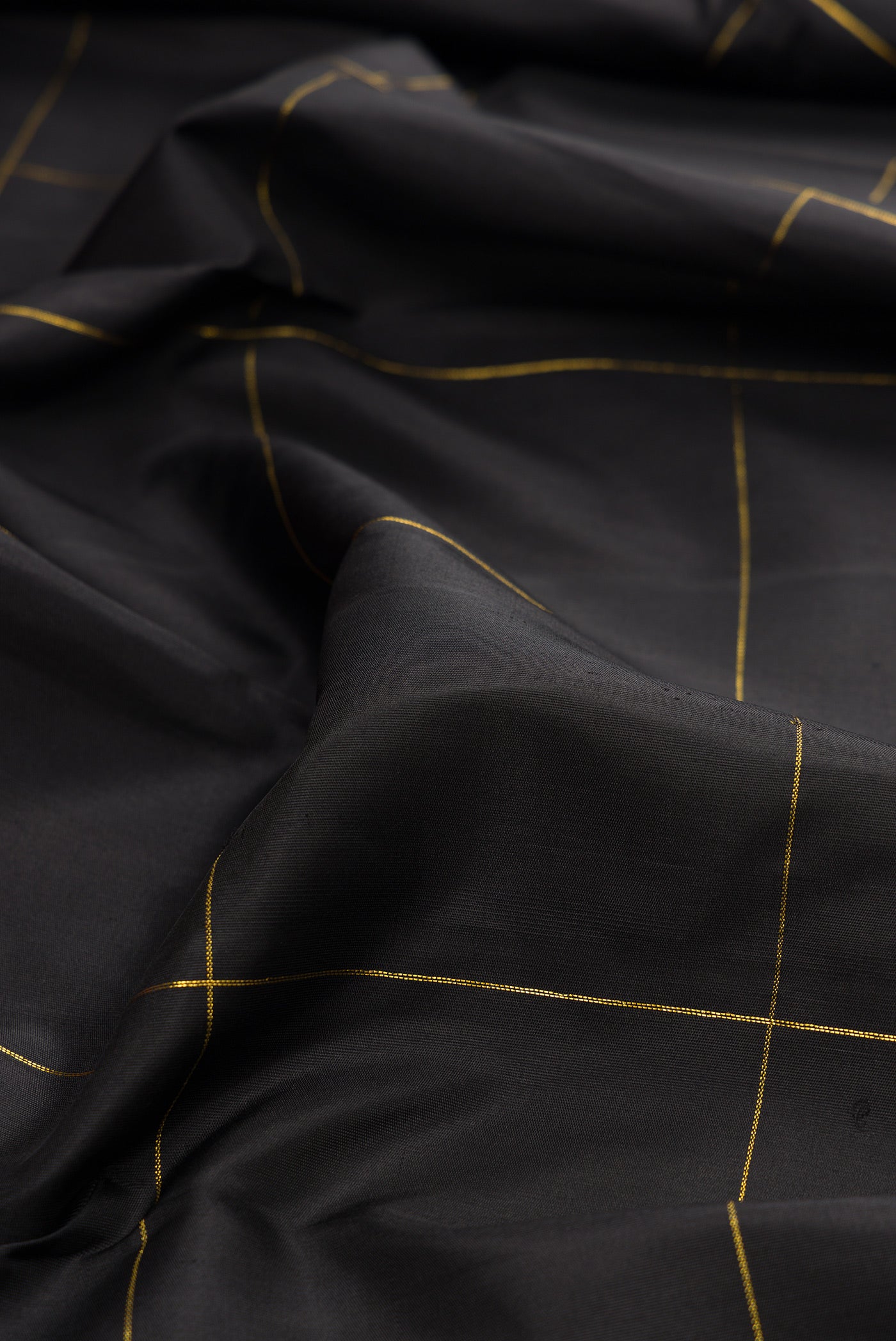 Close up of Black Kanchipuram Silk Saree with Checked design on the body and Fancy Border.  displaying folds