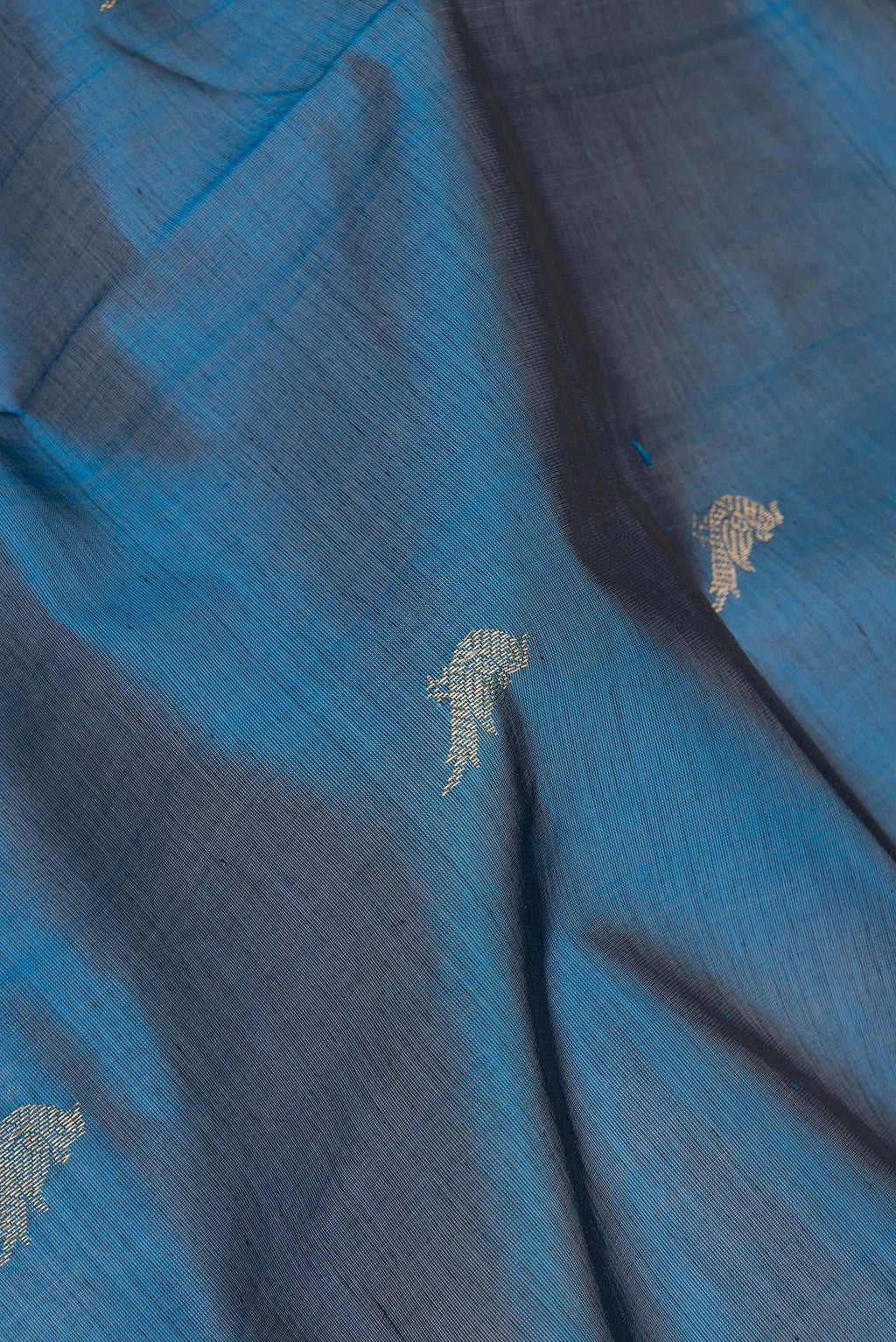 Close up of Peacock Blue Dual Tone Silk Cotton Saree with Zari Butta on the body and Zari Border.  displaying folds