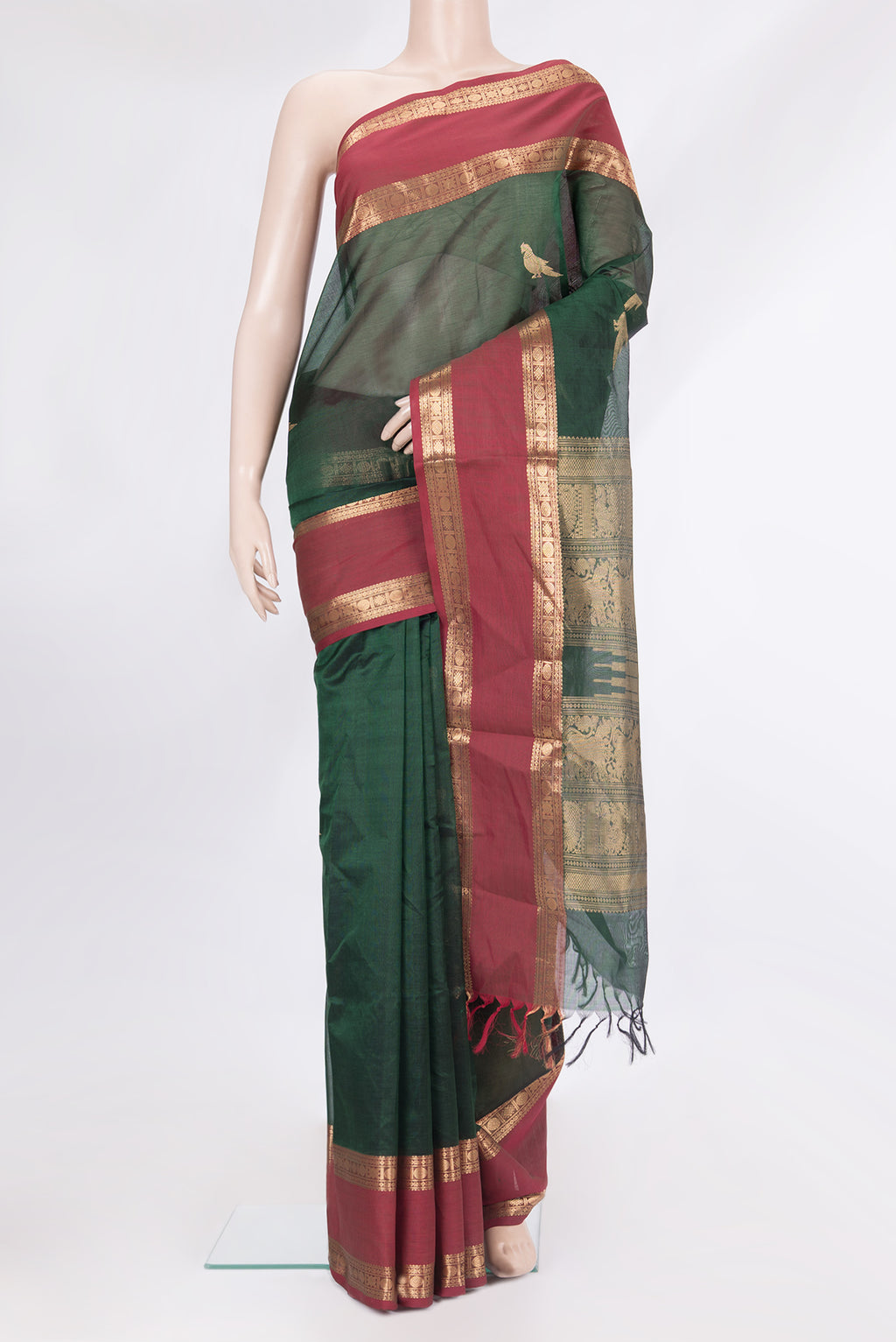 Bottle Green Silk Cotton Saree with Zari Butta on the body and Zari Border.  displayed on a mannequin