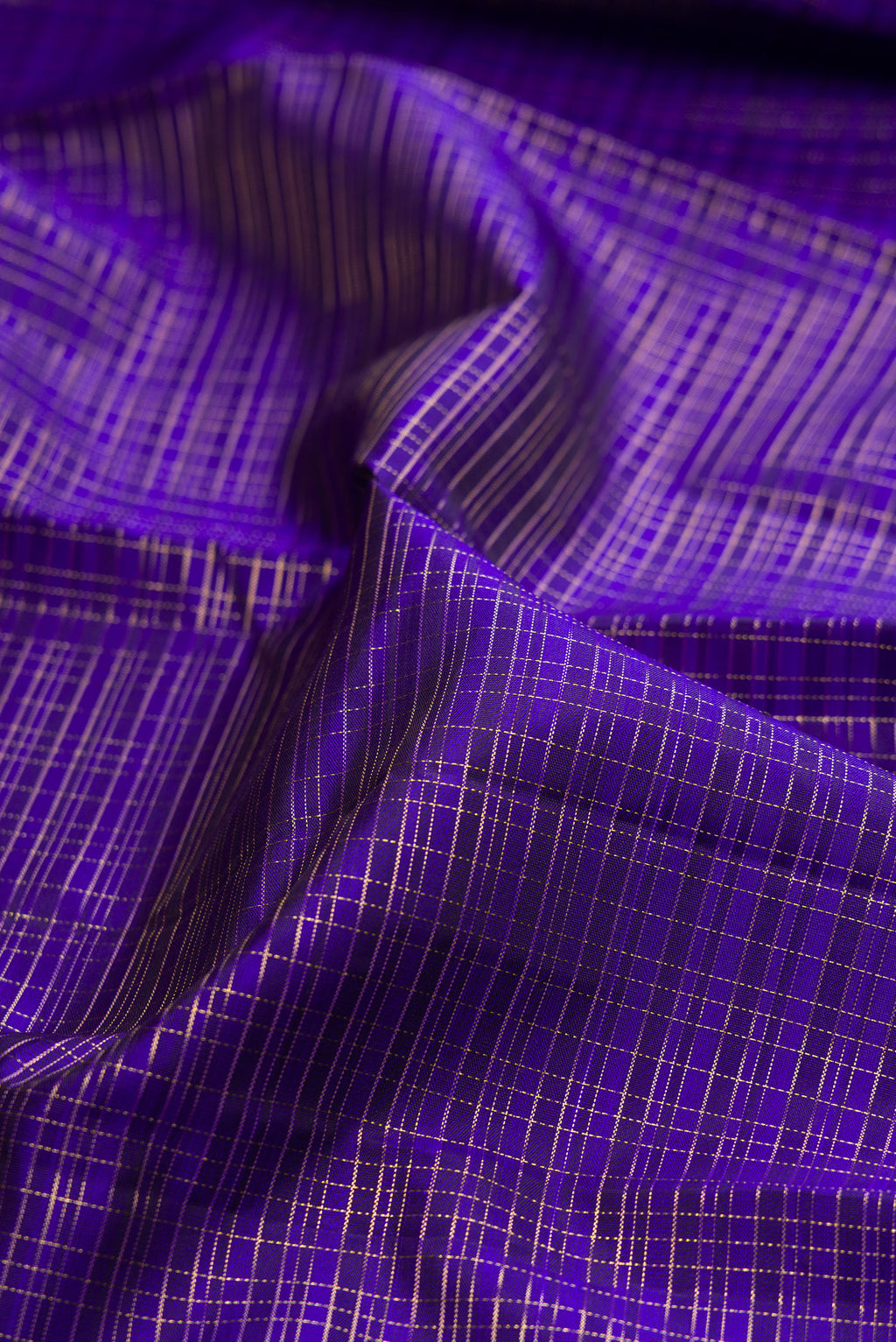 Close up of Royal Blue Kanchipuram Silk Saree with Checked design on the body and Zari Border.  displaying folds